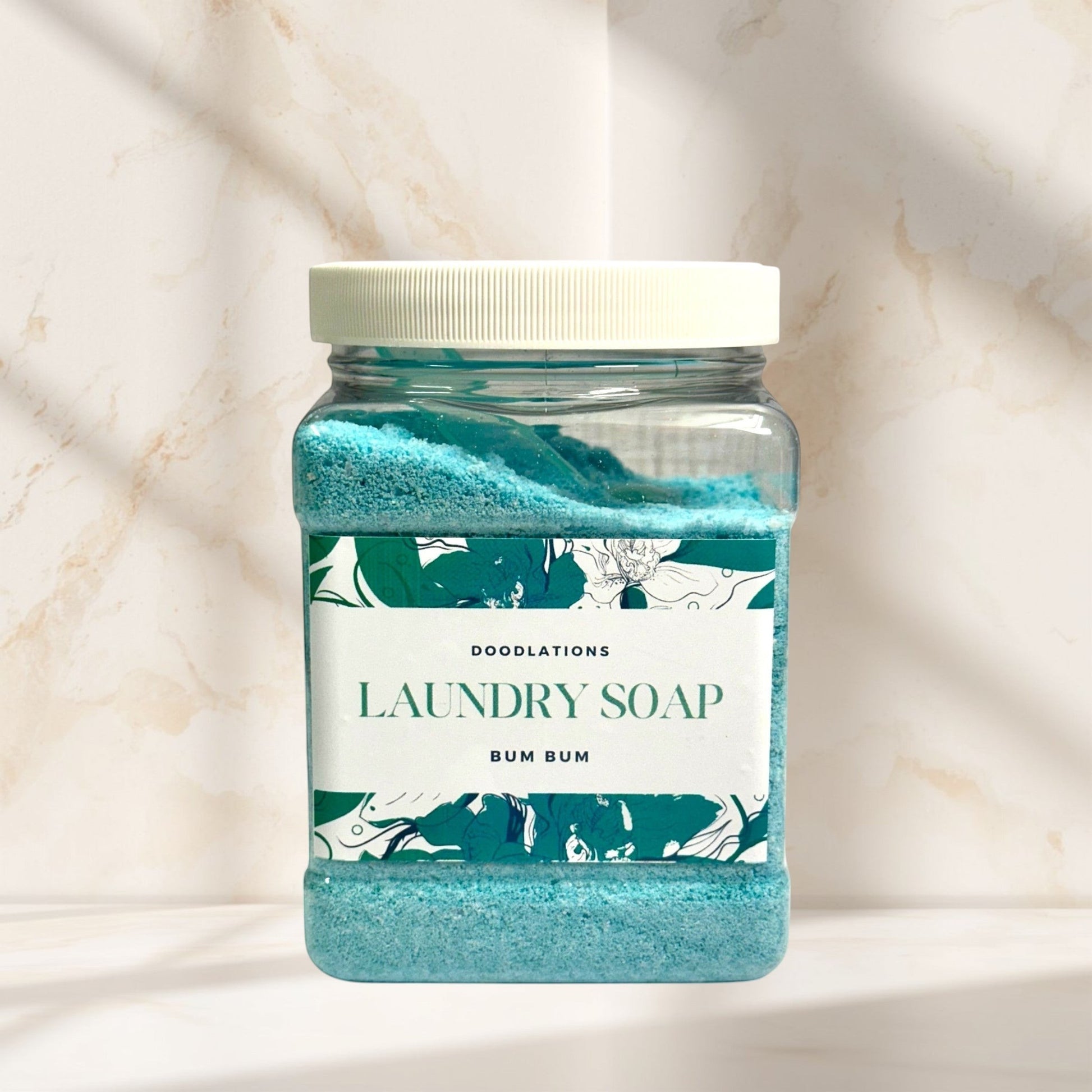 Doodlations Luxury Laundry Powder in Bum Bum scent, a blue granular detergent in a clear jar with a floral label.