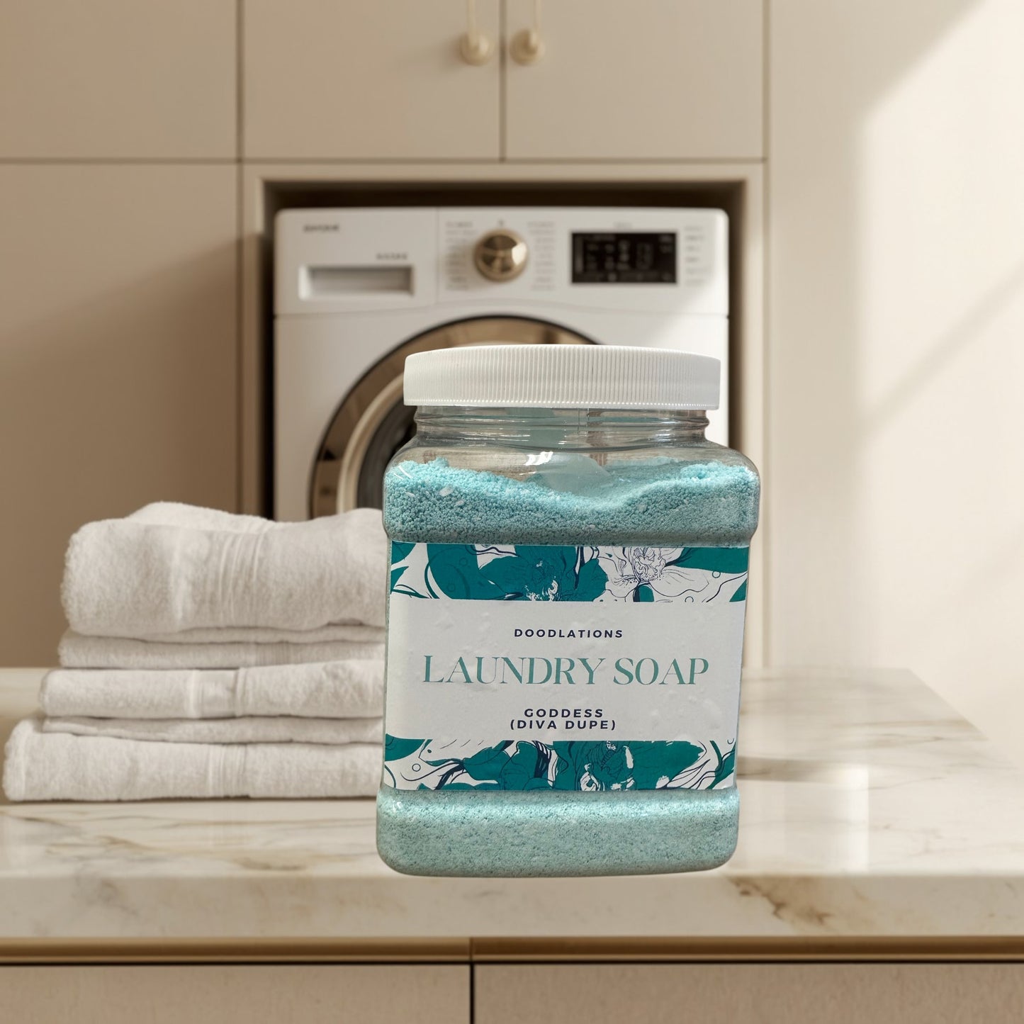 Doodlations Goddess luxury laundry powder in a clear jar with a white lid. Blue powder with floral label.