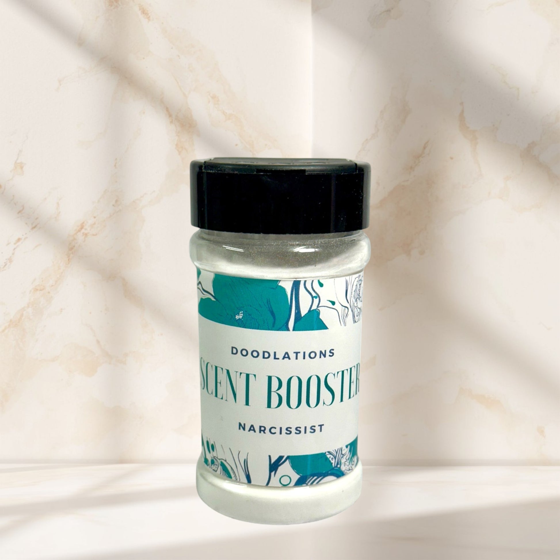 Doodlations Narcissist laundry scent booster in a clear plastic shaker bottle with a black lid. Features floral designs.