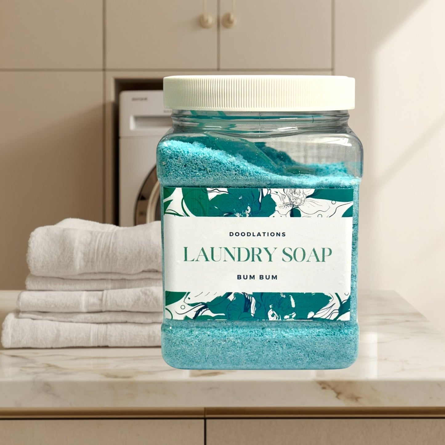 Doodlations Luxury Laundry Soap Bum Bum, a blue granular detergent in a clear plastic jar with a white lid.