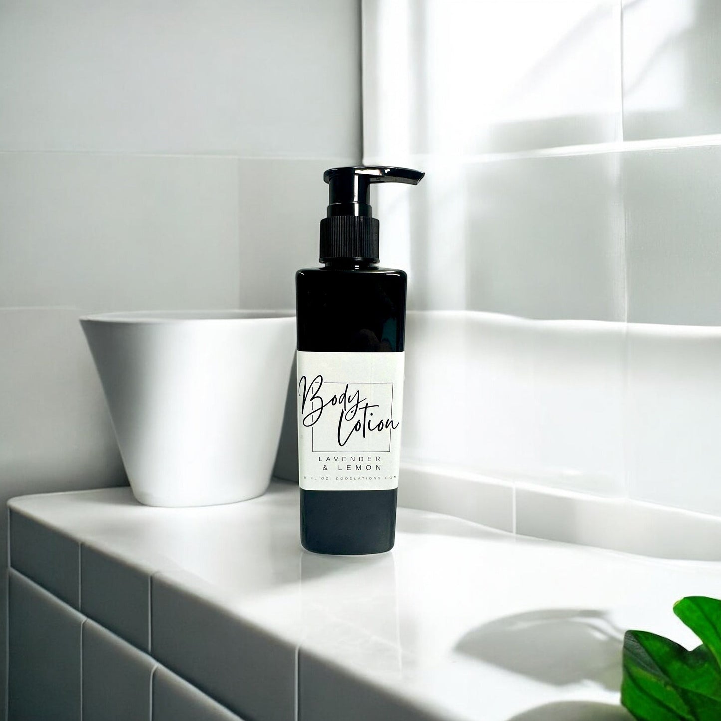 Doodlations Coffee Bar & Boutique black pump bottle of Lavender & Lemon body lotion on a white tiled surface.