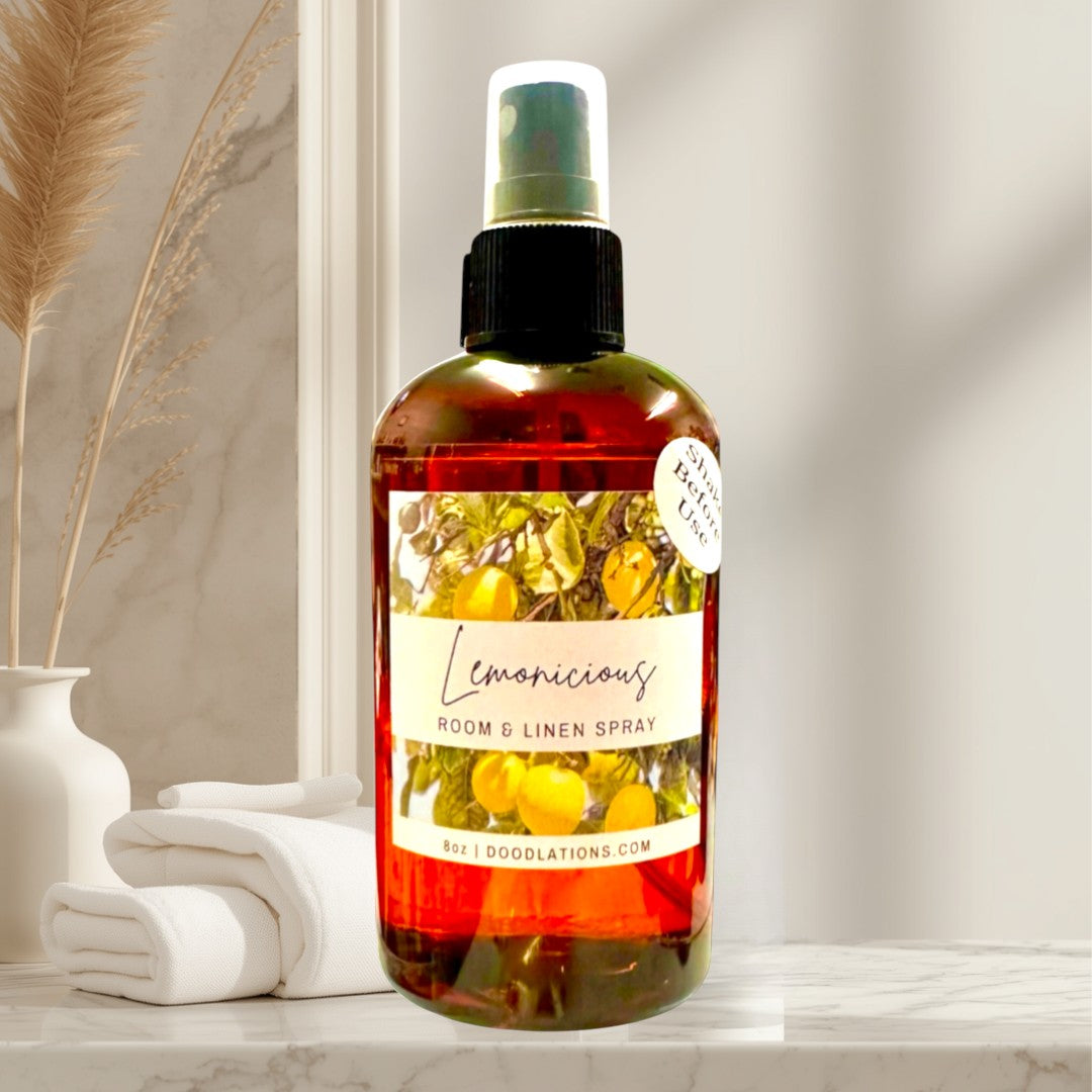 Doodlations Coffee Bar & Boutique Lemonicious Room & Linen Spray with lemon scent in amber bottle.