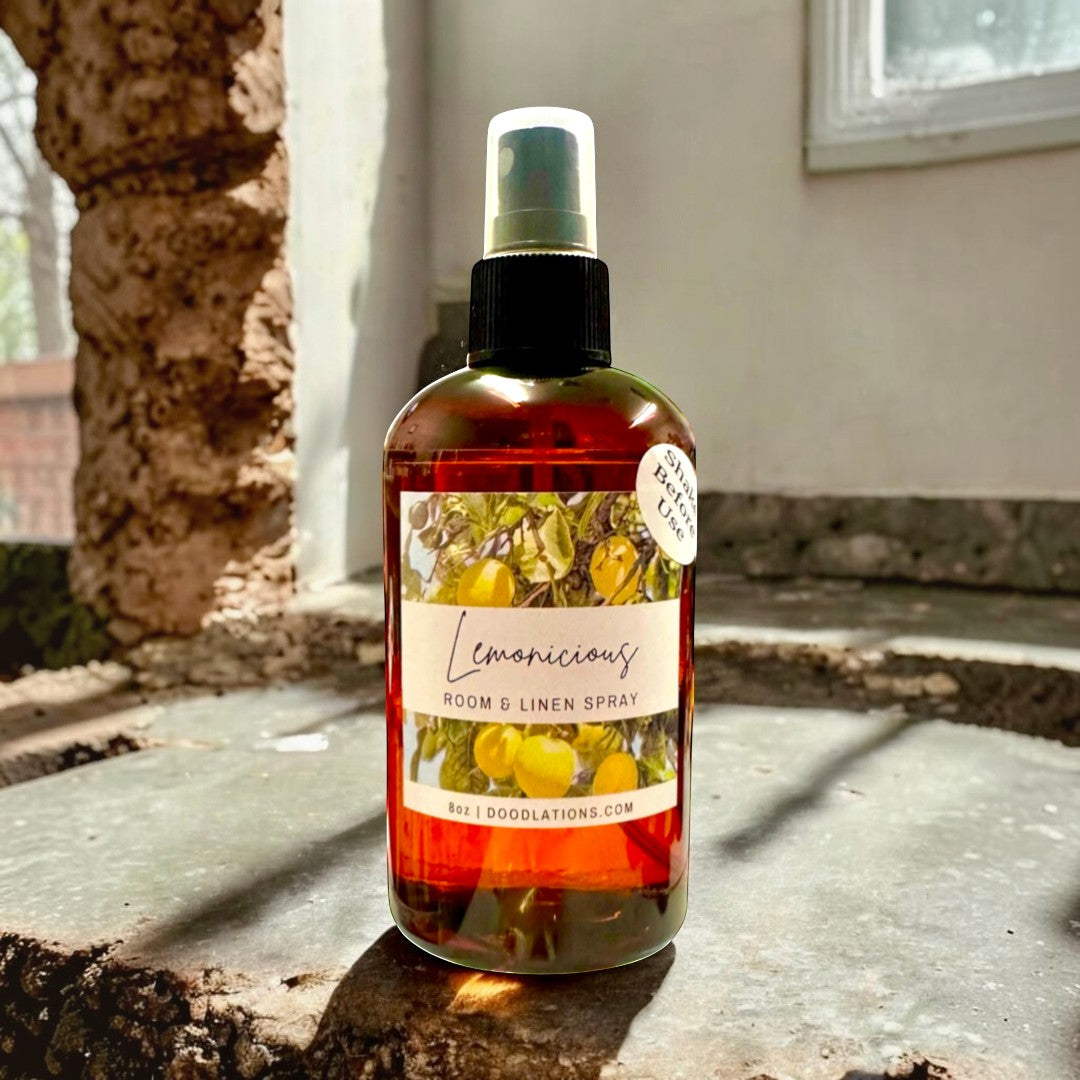 Doodlations Coffee Bar & Boutique Lemonicious Room & Linen Spray with lemon scent in amber bottle.