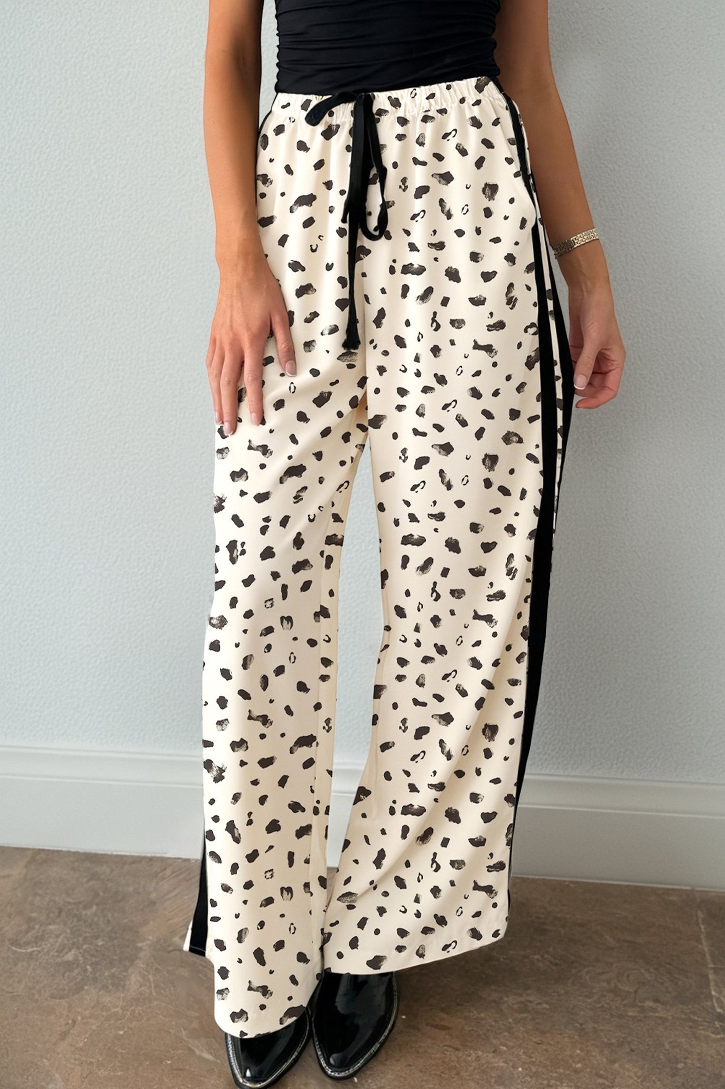 Doodlations Coffee Bar & Boutique beige leopard print loose drawstring pants with black side stripe detail.