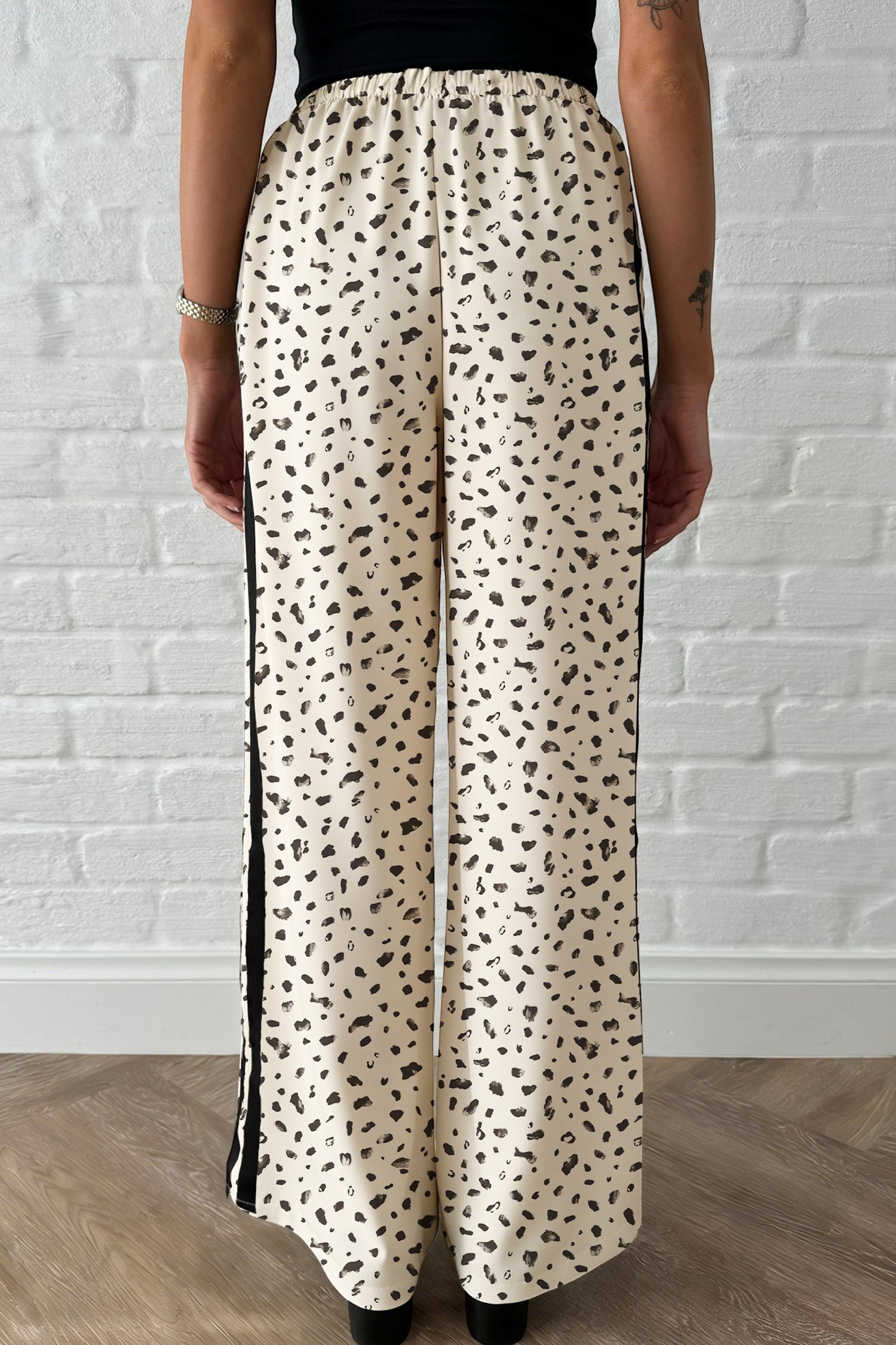 Doodlations Coffee Bar & Boutique beige leopard print loose drawstring pants with black side stripe detail.