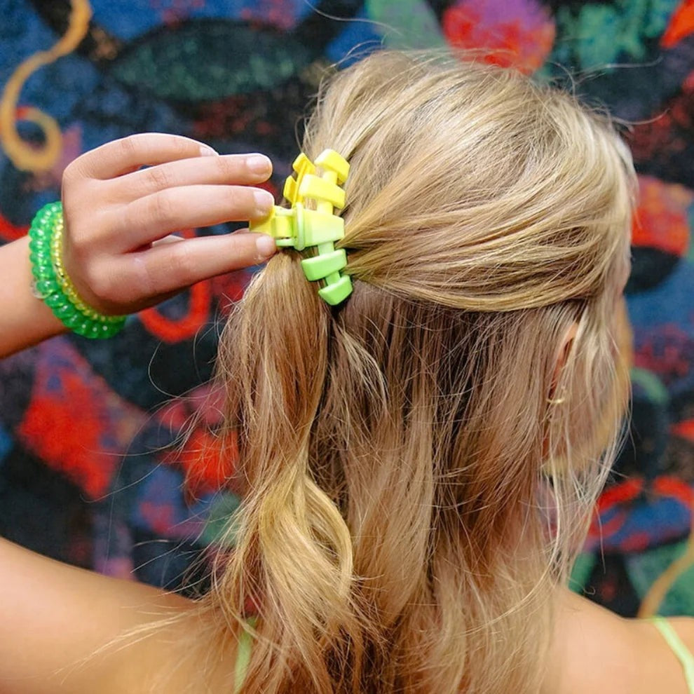 Doodlations Coffee Bar & Boutique lime green gradient segmented claw hair clip holding blonde hair in a ponytail.