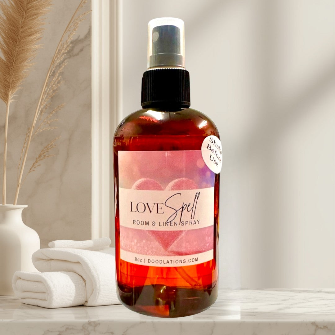 Doodlations Coffee Bar & Boutique Love Spell Room & Linen Spray, 8oz amber glass bottle with spray top. Scent blend of fruit and floral with orange and grapefruit notes.