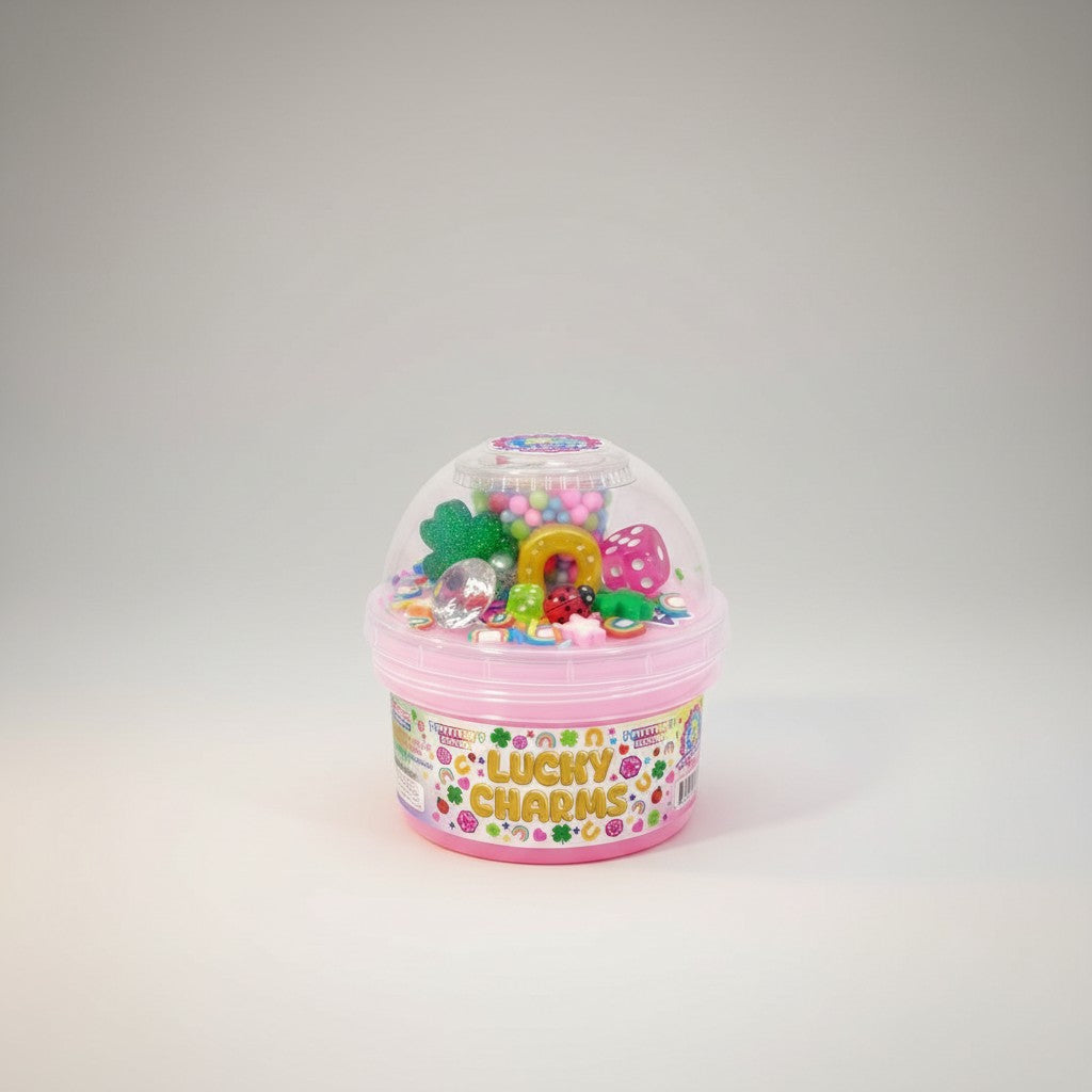 Doodlations Lucky Charms mystery slime in a pink container with a clear lid, filled with colorful charms like dice, ladybugs, horseshoes, and glittery shamrocks.