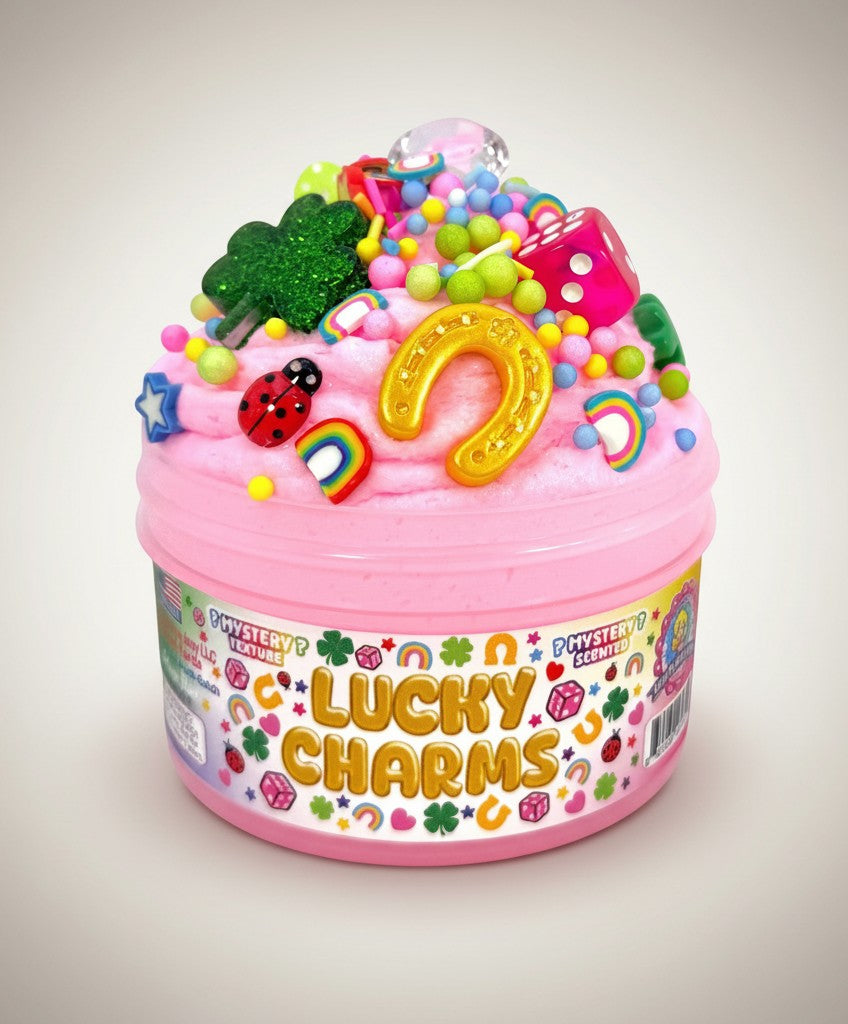 Doodlations Coffee Bar & Boutique Lucky Charms pink mystery slime topped with gold horseshoe, green shamrock, dice, ladybugs, rainbows, and colorful beads.