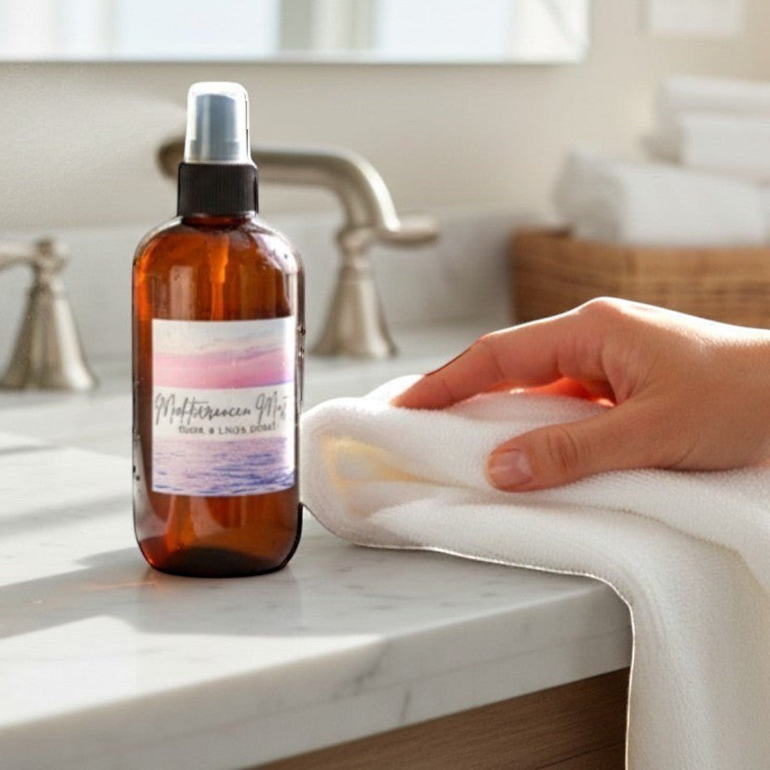 Doodlations Coffee Bar & Boutique Mediterranean Mist room and linen spray in amber bottle on bathroom counter.