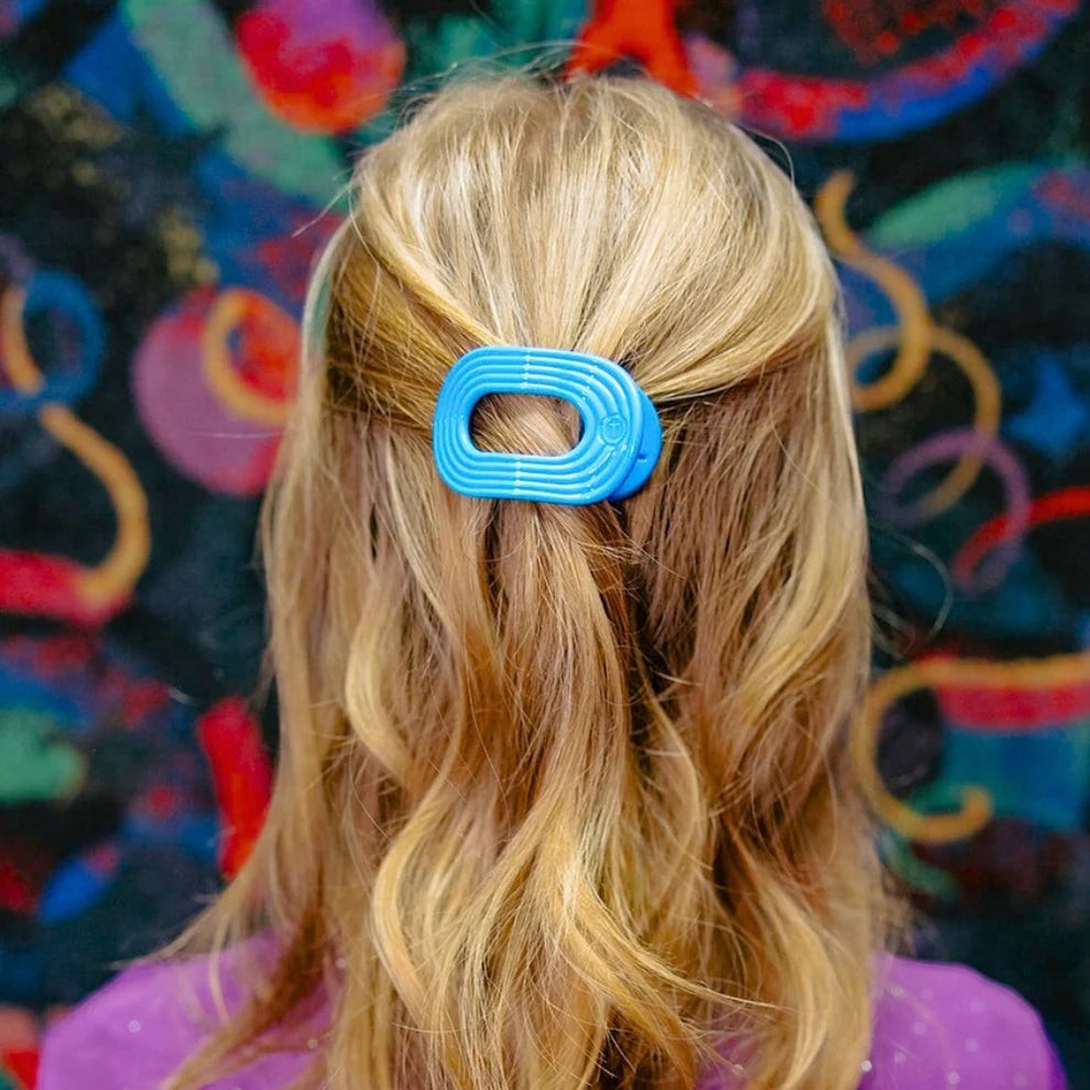 Doodlations Coffee Bar & Boutique Miami Vice blue flat round hair clip with a no-slip grip.