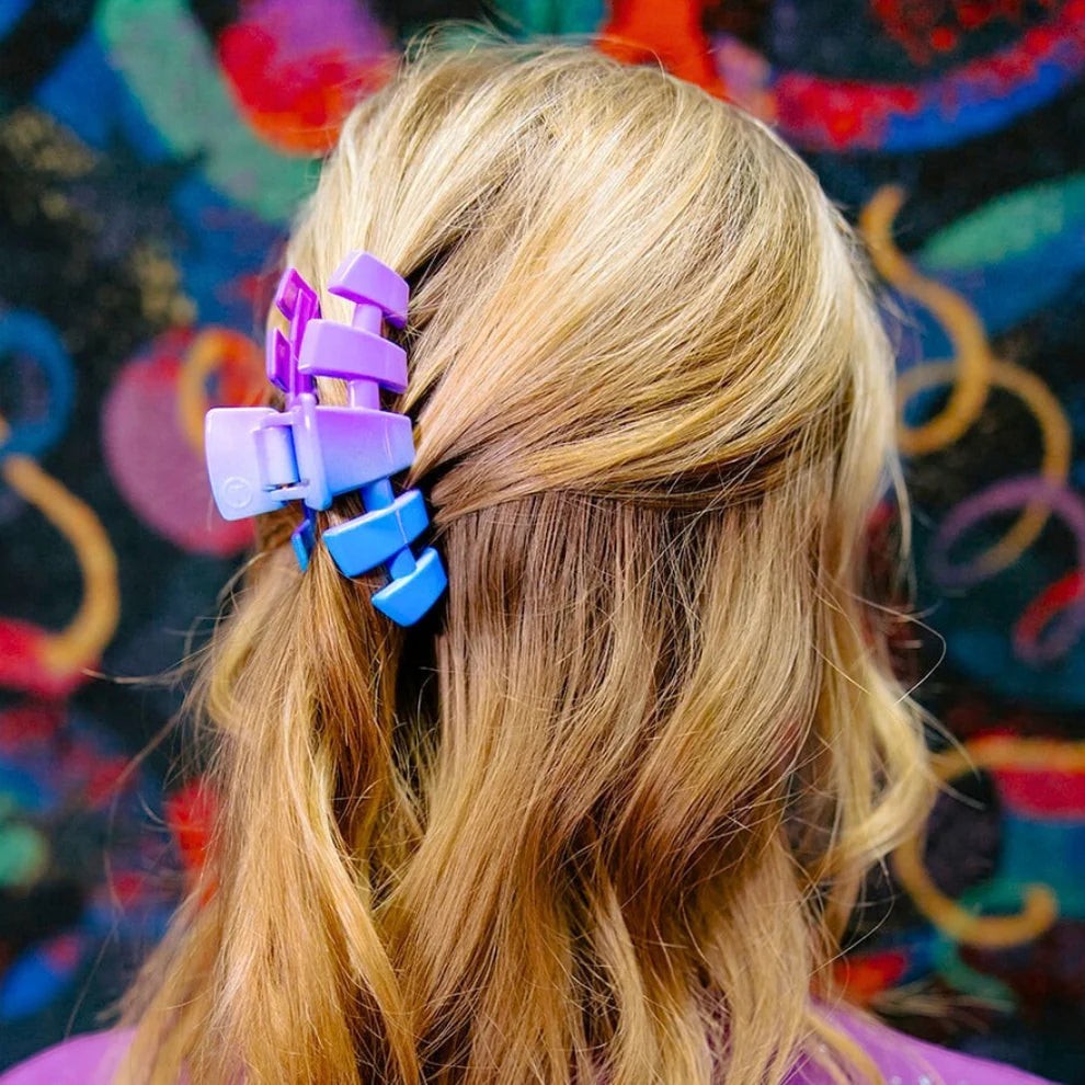 Doodlations Coffee Bar & Boutique Miami Vice claw clip in blue and purple gradient plastic, holding back blonde hair.