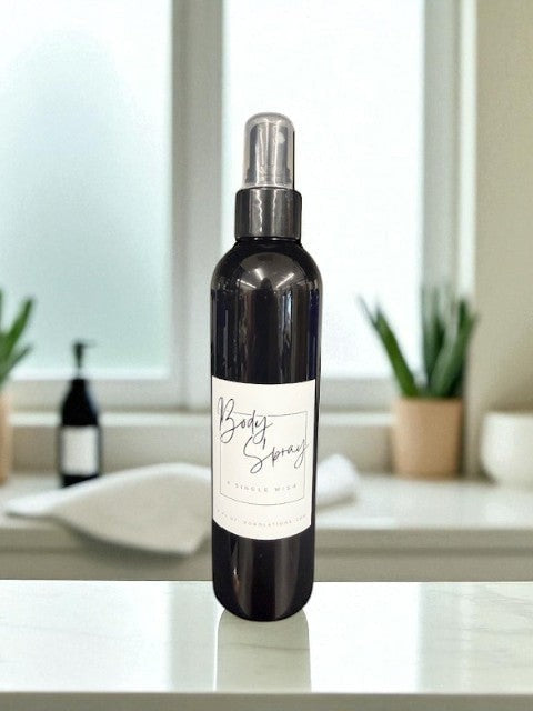 Doodlations Moisturizing Body Spray in a dark bottle with a white label, featuring aloe and hydrating butters.