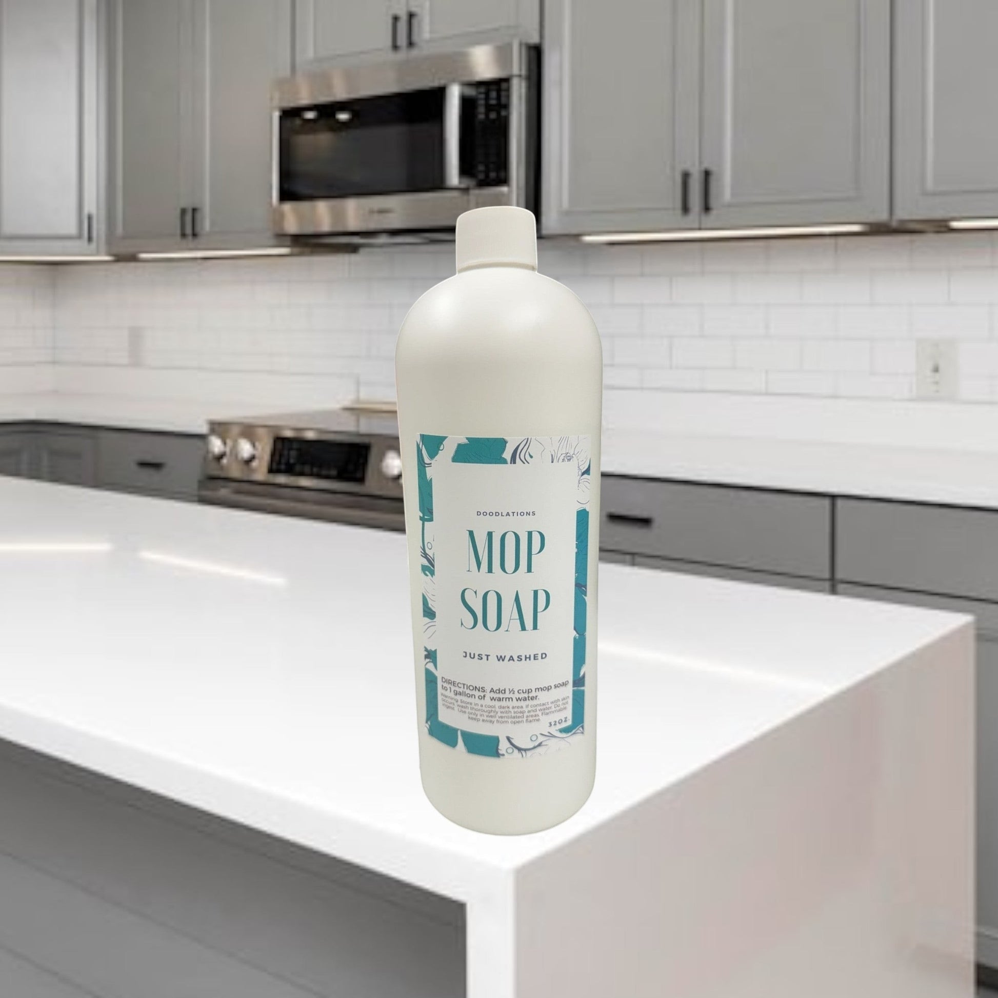 Doodlations Mop Soap, concentrated floor cleaner in a white bottle with a teal floral label, next to a gold mop.