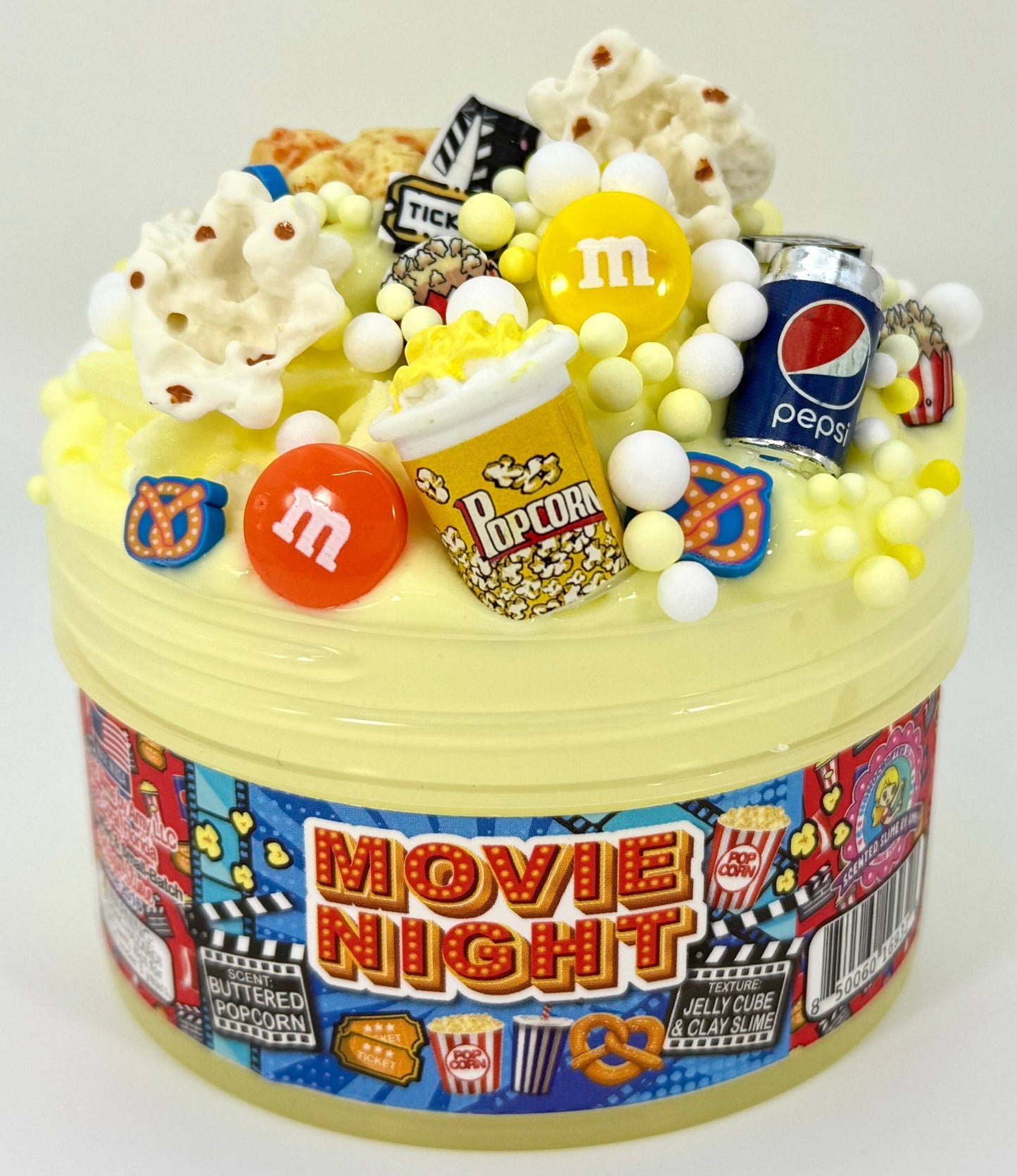 Doodlations Movie Night jelly cube clay slime with popcorn, M&Ms, Pepsi can, and movie ticket charms. Scented like buttered popcorn.
