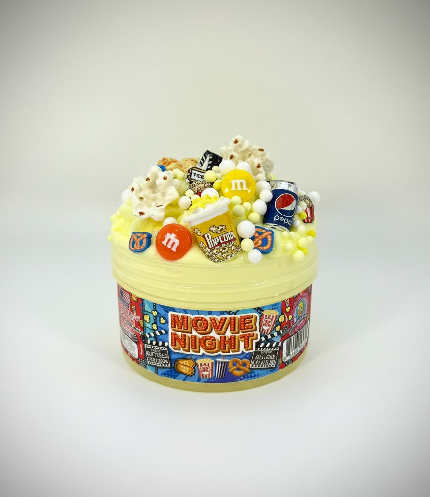 Doodlations Movie Night jelly cube clay slime with popcorn, M&Ms, Pepsi can, and movie ticket charms. Scented like buttered popcorn.