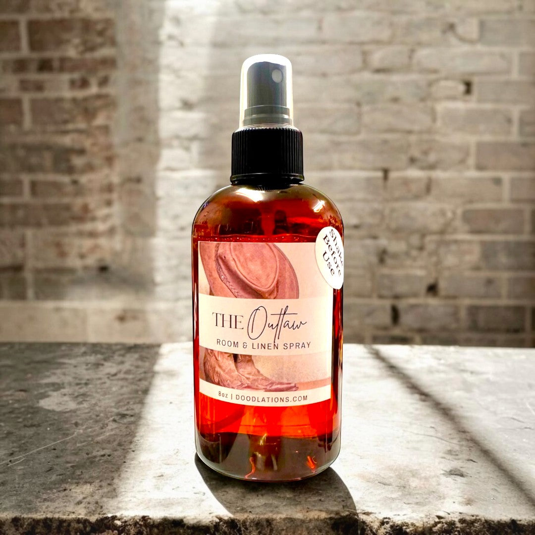 Doodlations Coffee Bar & Boutique The Outlaw room and linen spray in amber bottle with cowboy hat and boots label.