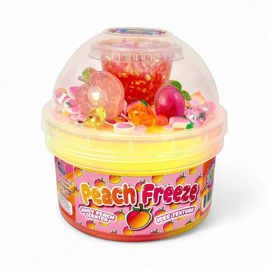 Doodlations Peach Freeze Iced Texture Slime with peach charms, glitter, and candy add-ins in a yellow tub with a clear dome lid.