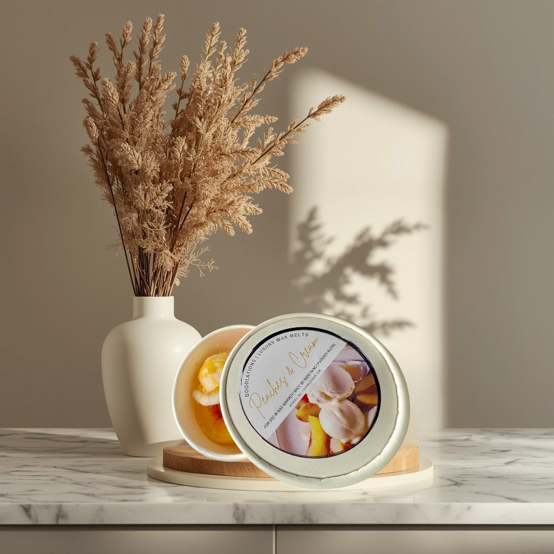 Doodlations Peaches & Cream wax melts in a white container, resembling scoops of ice cream with peach slices.