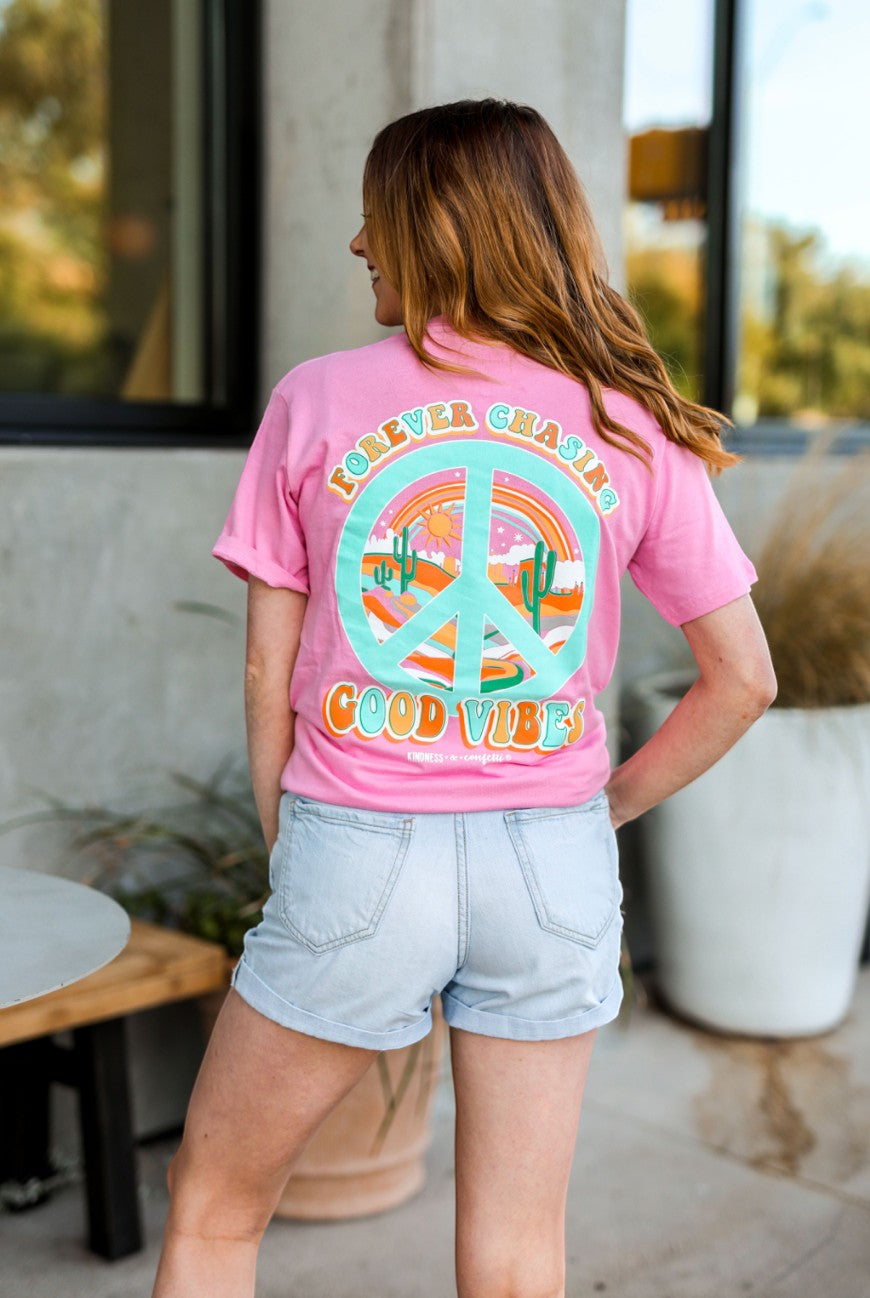 Doodlations Coffee Bar & Boutique pink cotton graphic tee with peace sign, desert landscape, and "Forever Chasing Good Vibes" text.