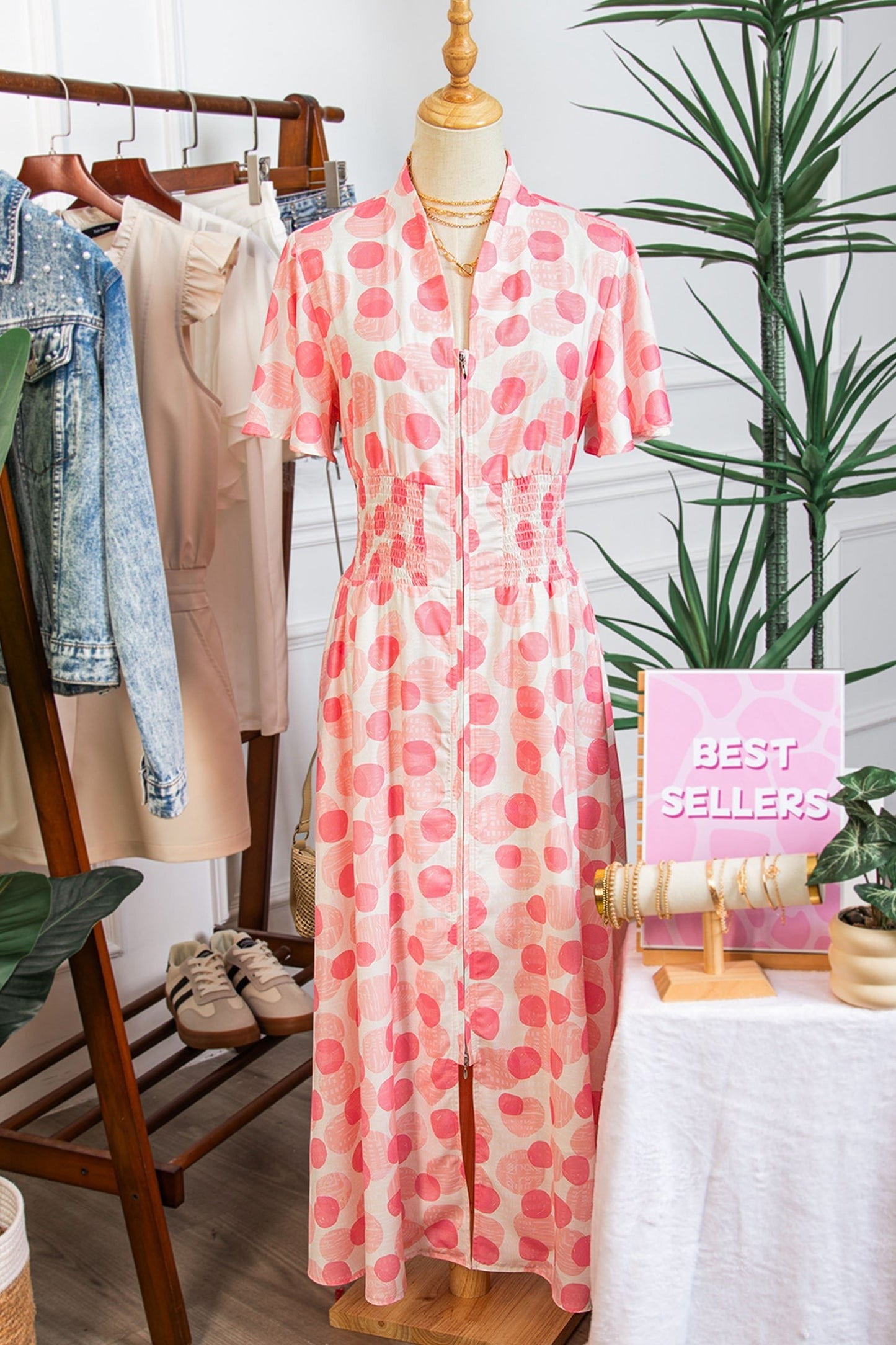 Doodlations Coffee Bar & Boutique pink and white polka dot midi dress with smocked waist and flutter sleeves.