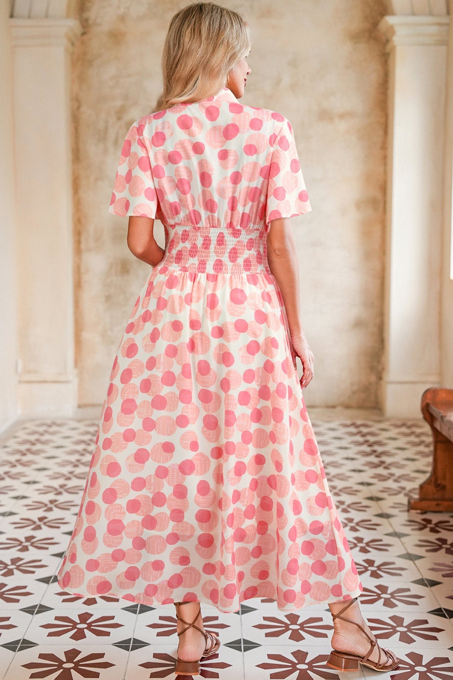 Doodlations Coffee Bar & Boutique pink and white polka dot midi dress with smocked waist and flutter sleeves.