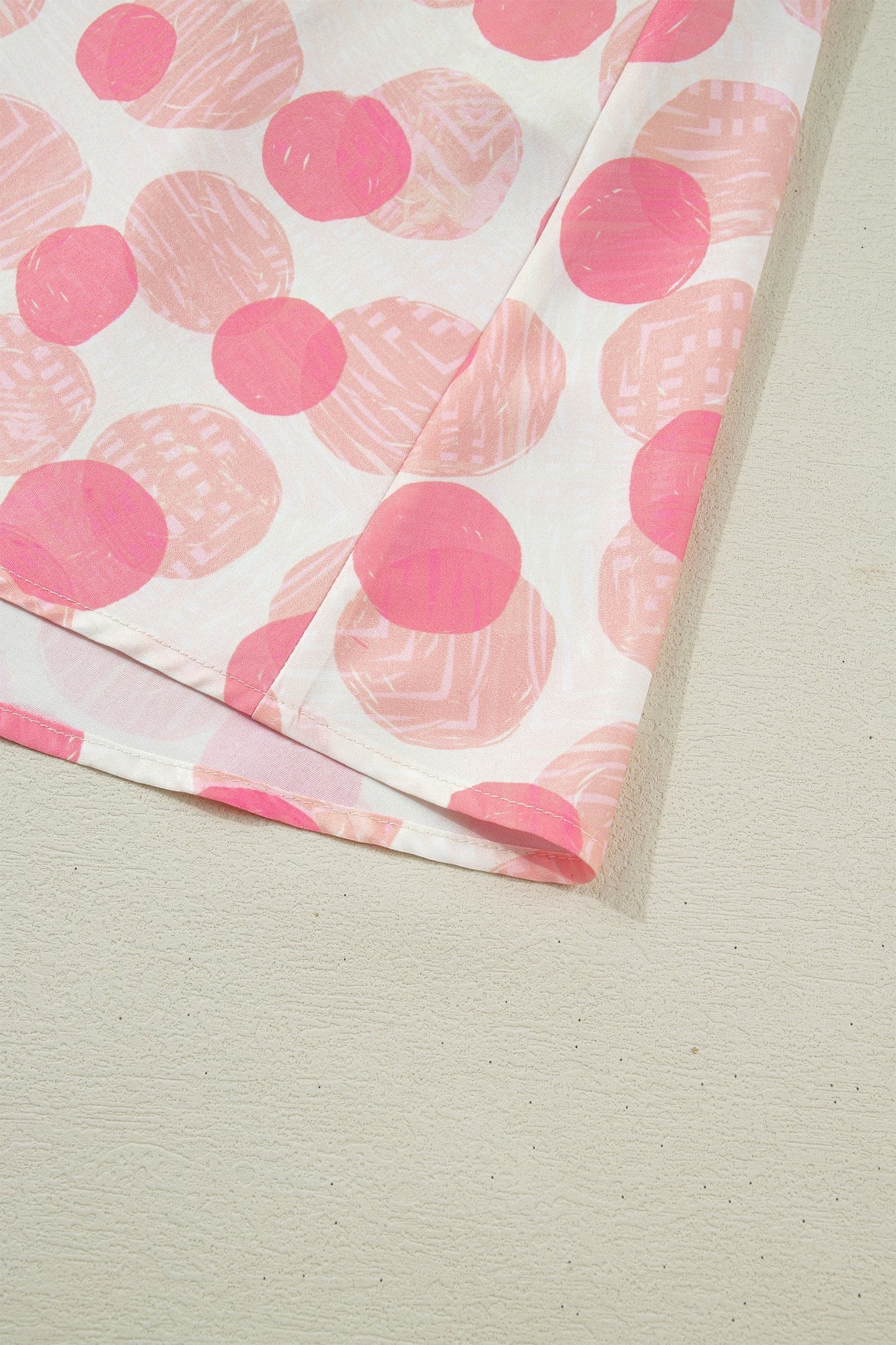 Doodlations Coffee Bar & Boutique pink and white polka dot midi dress with smocked waist and flutter sleeves.