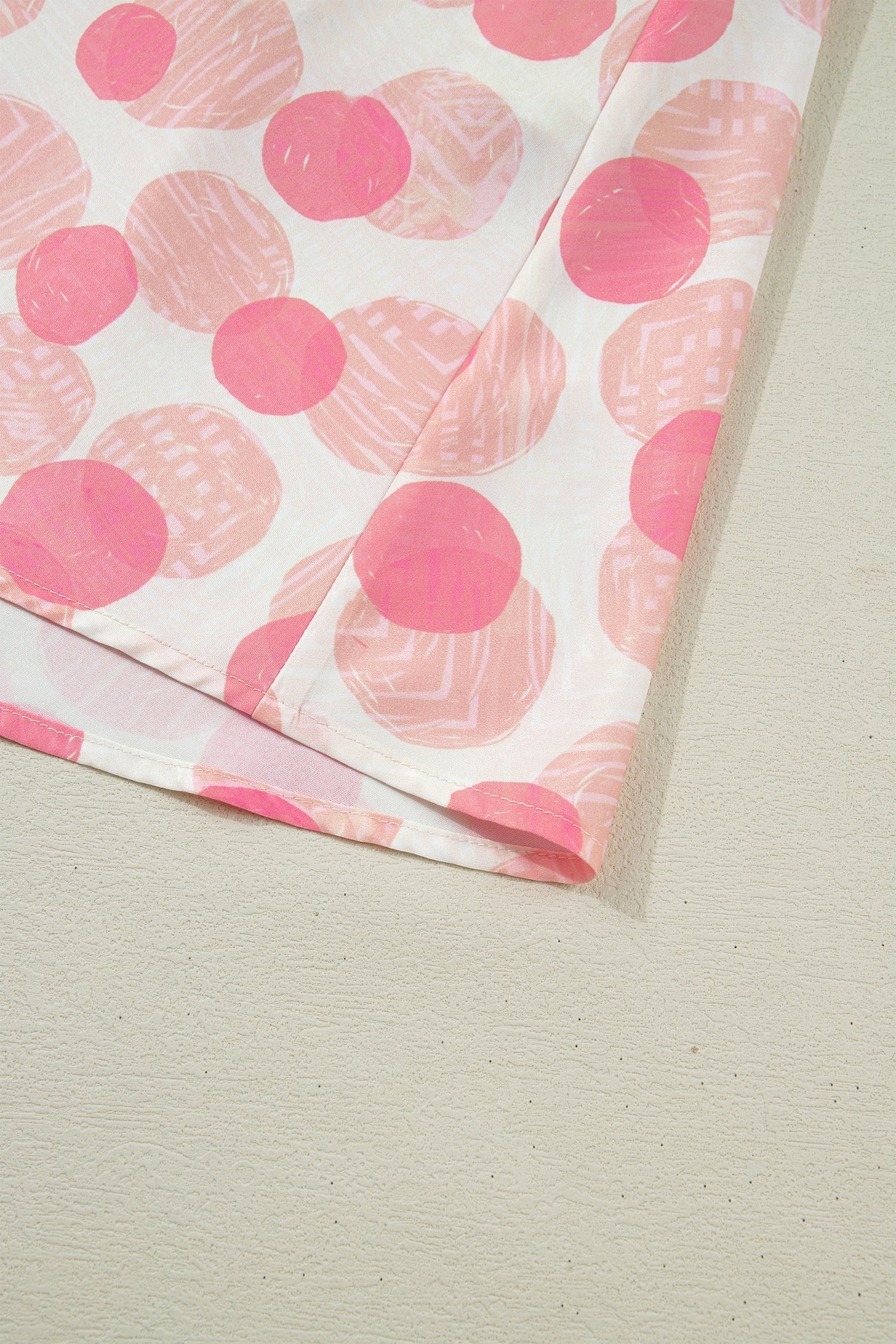 Doodlations Coffee Bar & Boutique pink and white polka dot midi dress with smocked waist and flutter sleeves.