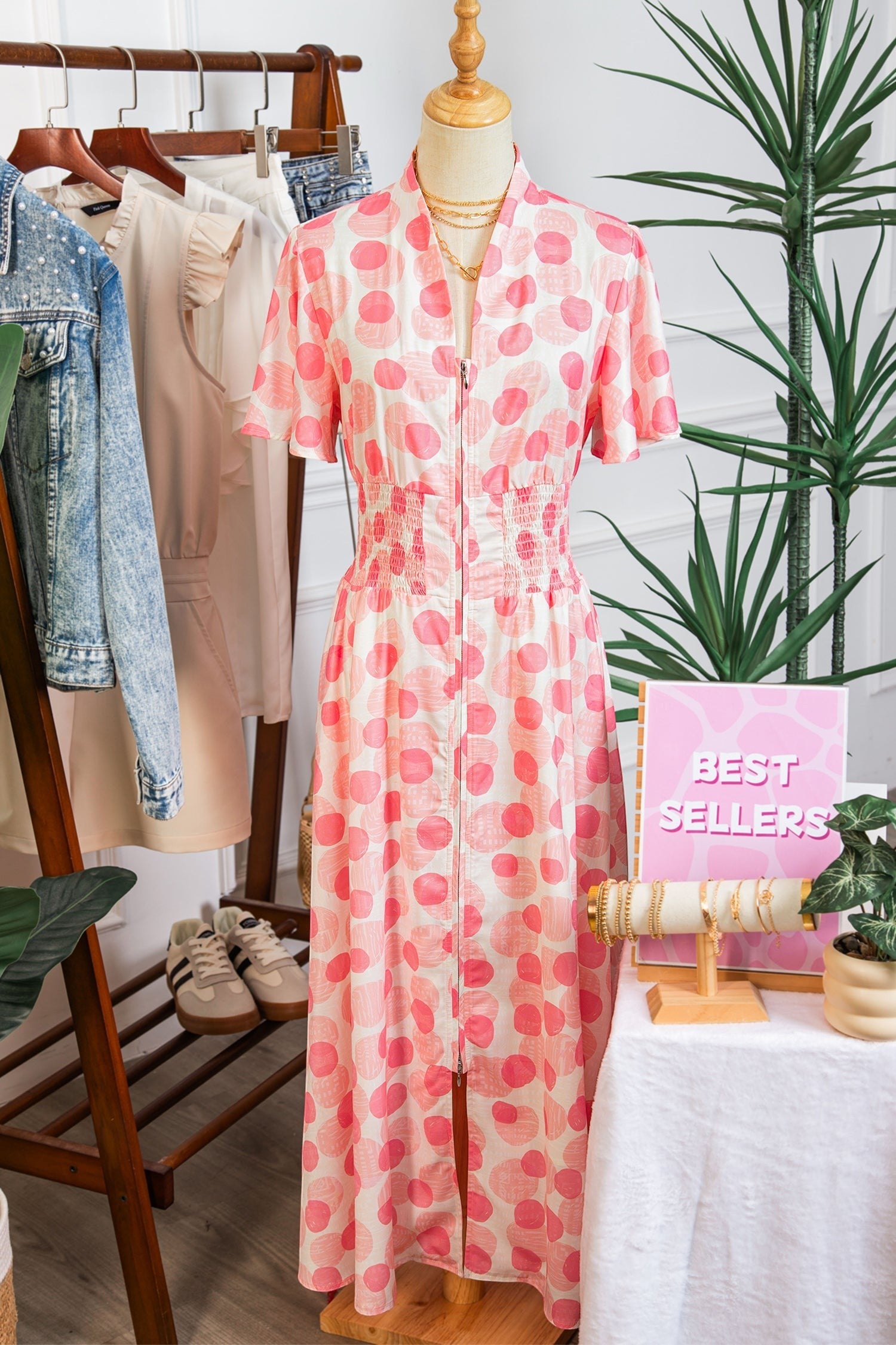 Doodlations Coffee Bar & Boutique pink and white polka dot midi dress with smocked waist and flutter sleeves.