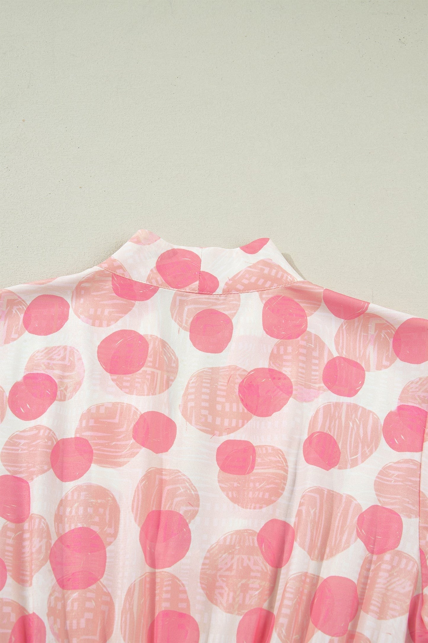 Doodlations Coffee Bar & Boutique pink and white polka dot midi dress with smocked waist and flutter sleeves.