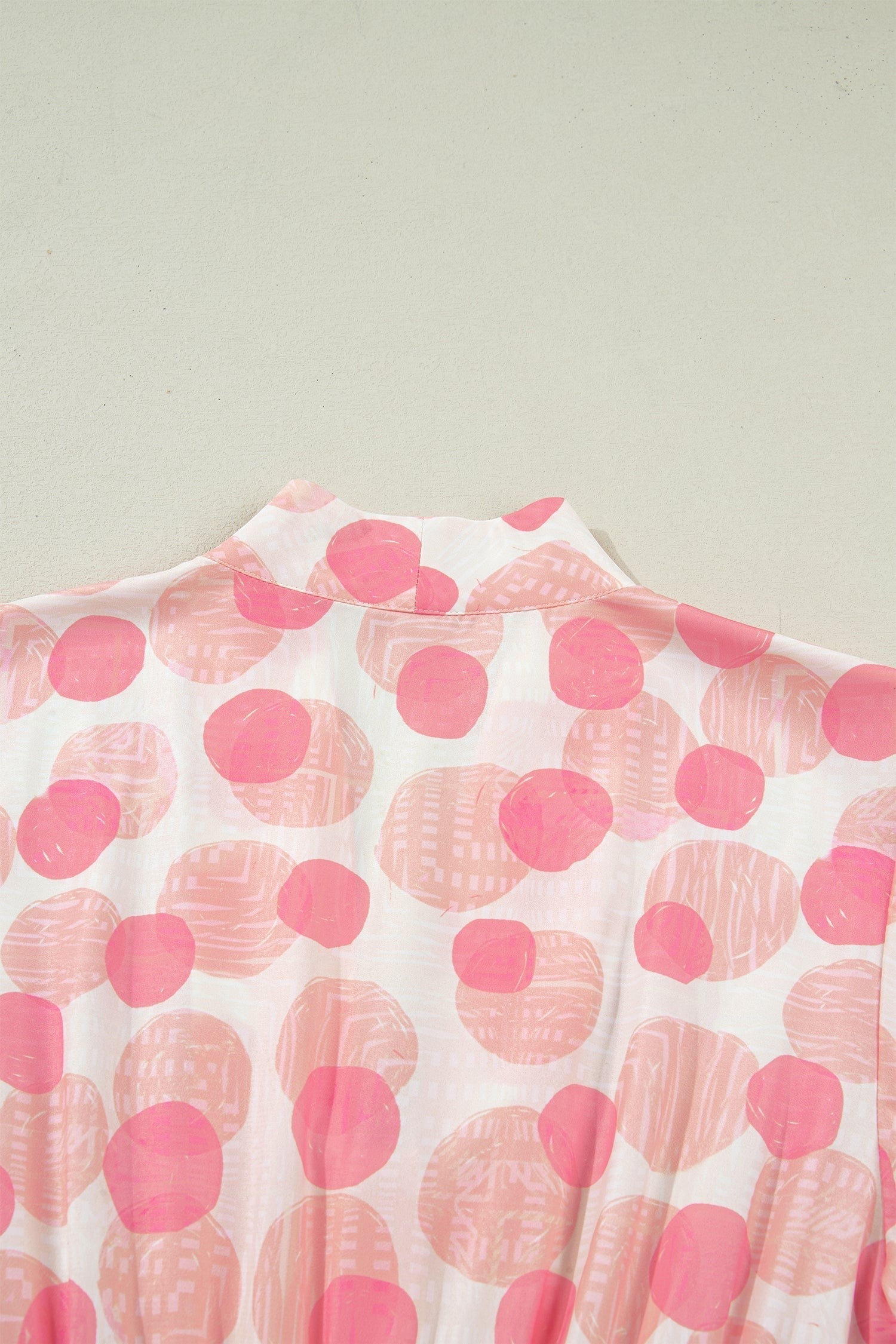 Doodlations Coffee Bar & Boutique pink and white polka dot midi dress with smocked waist and flutter sleeves.