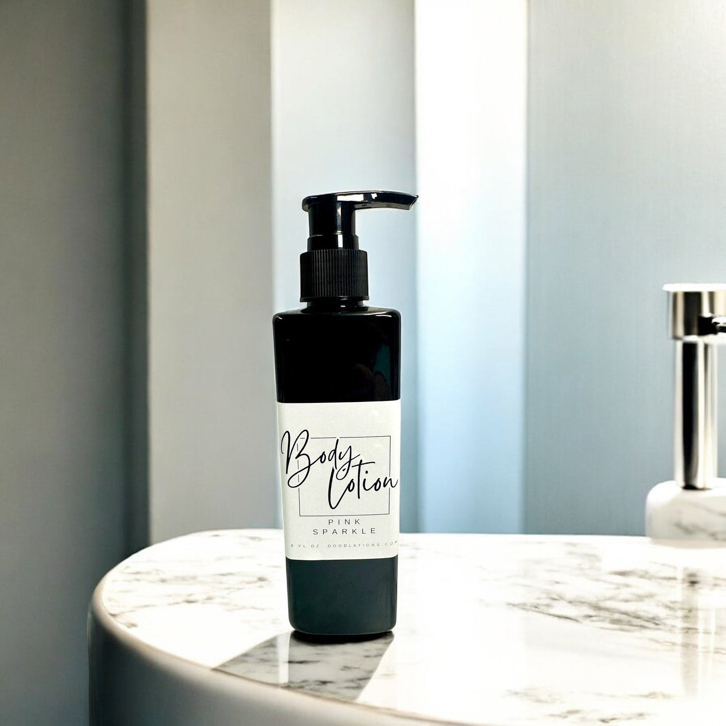Doodlations Coffee Bar & Boutique Pink Sparkle moisturizing body lotion in a black pump bottle on a marble surface.