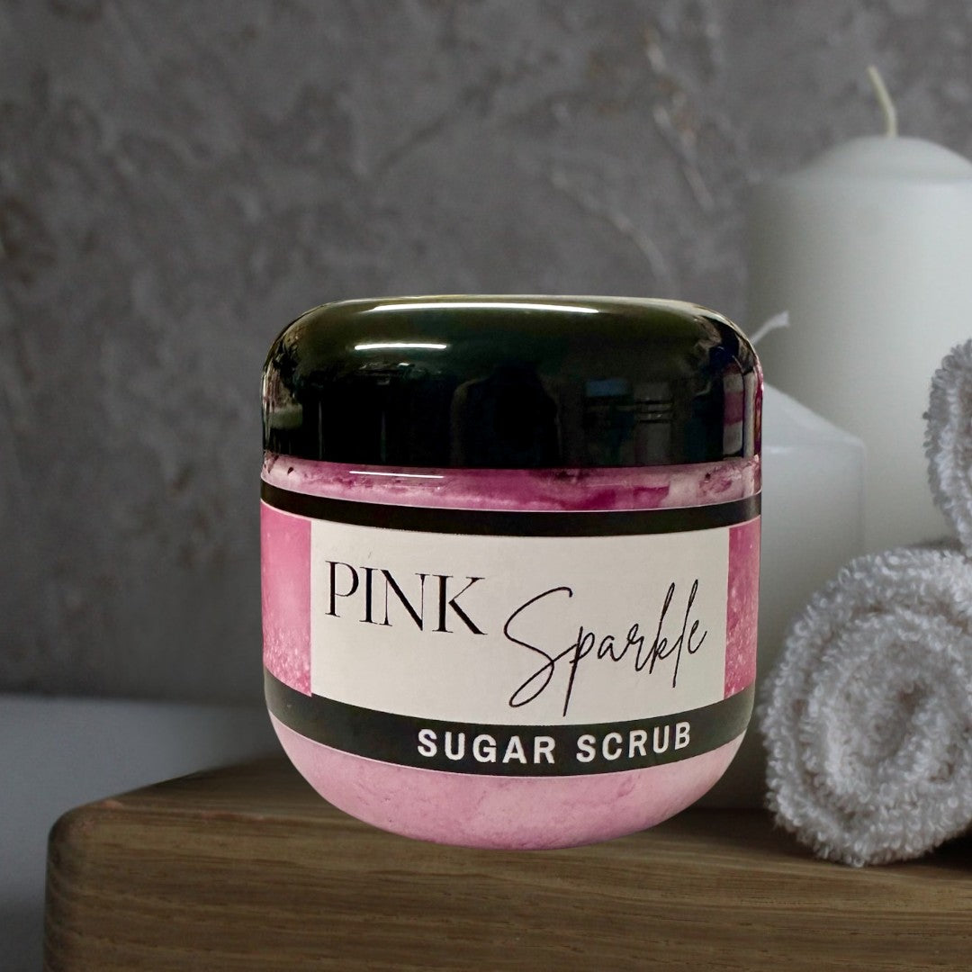 Doodlations Pink Sparkle Sugar Scrub, a luxurious exfoliating body scrub in a clear jar with a black lid and pink label.