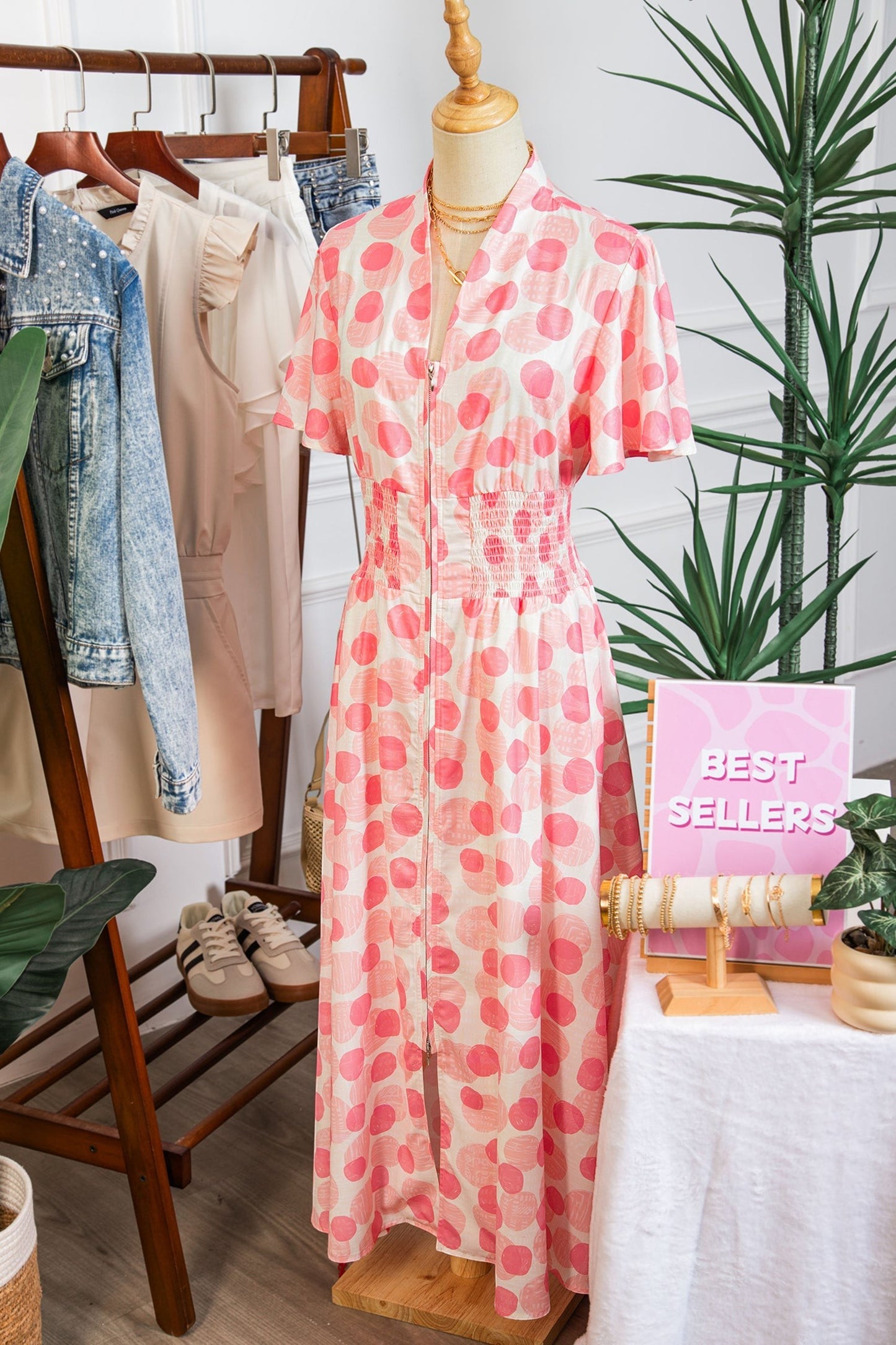 Doodlations Coffee Bar & Boutique pink and white polka dot midi dress with smocked waist and flutter sleeves.