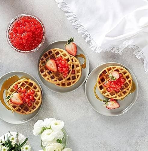 Doodlations Coffee Bar & Boutique Pomegranate Bursting Balls topping waffles with strawberries and syrup.