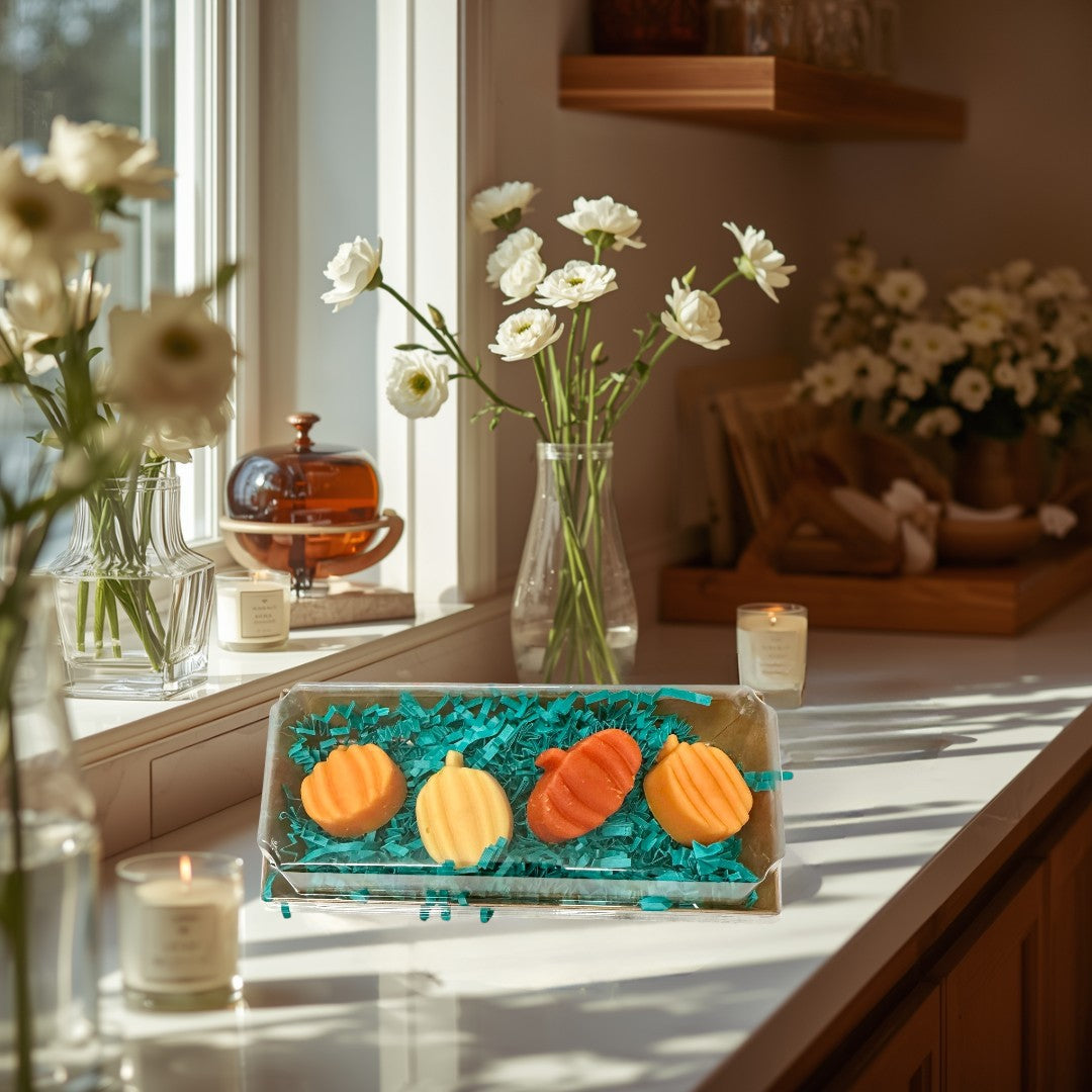 Doodlations Smashed Pumpkin wax melts in orange and yellow pumpkin shapes, nestled in teal crinkle paper.