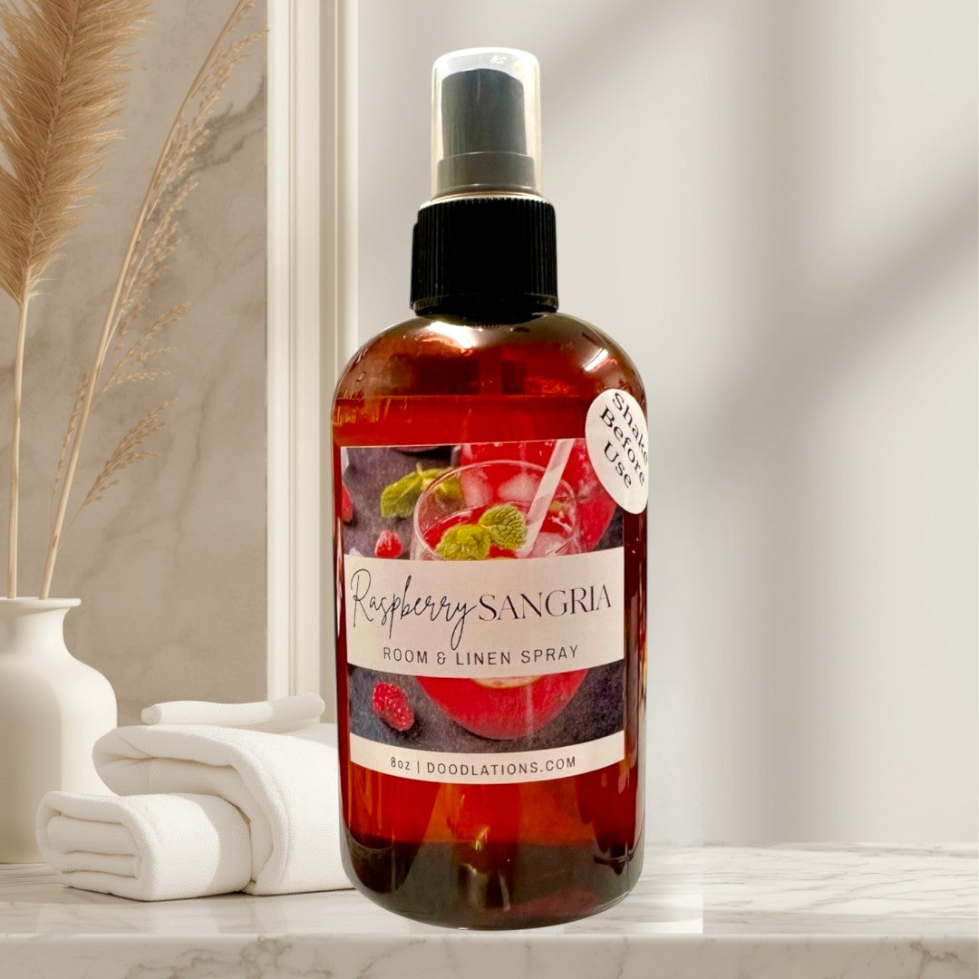 Doodlations Raspberry Sangria Room & Linen Spray bottle with a label featuring a sangria cocktail and raspberries.
