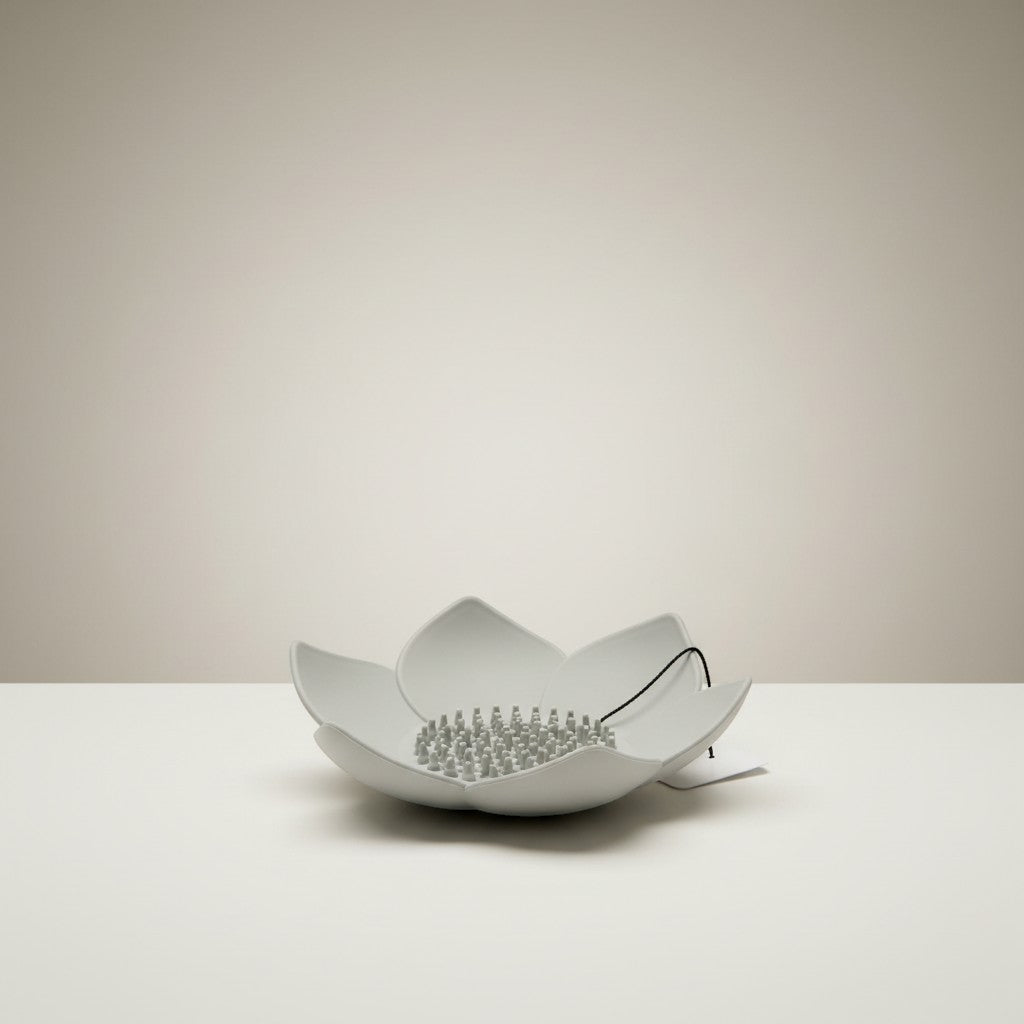 Doodlations Coffee Bar & Boutique white silicone lotus flower shower steamer holder with grey pegs and black cord.