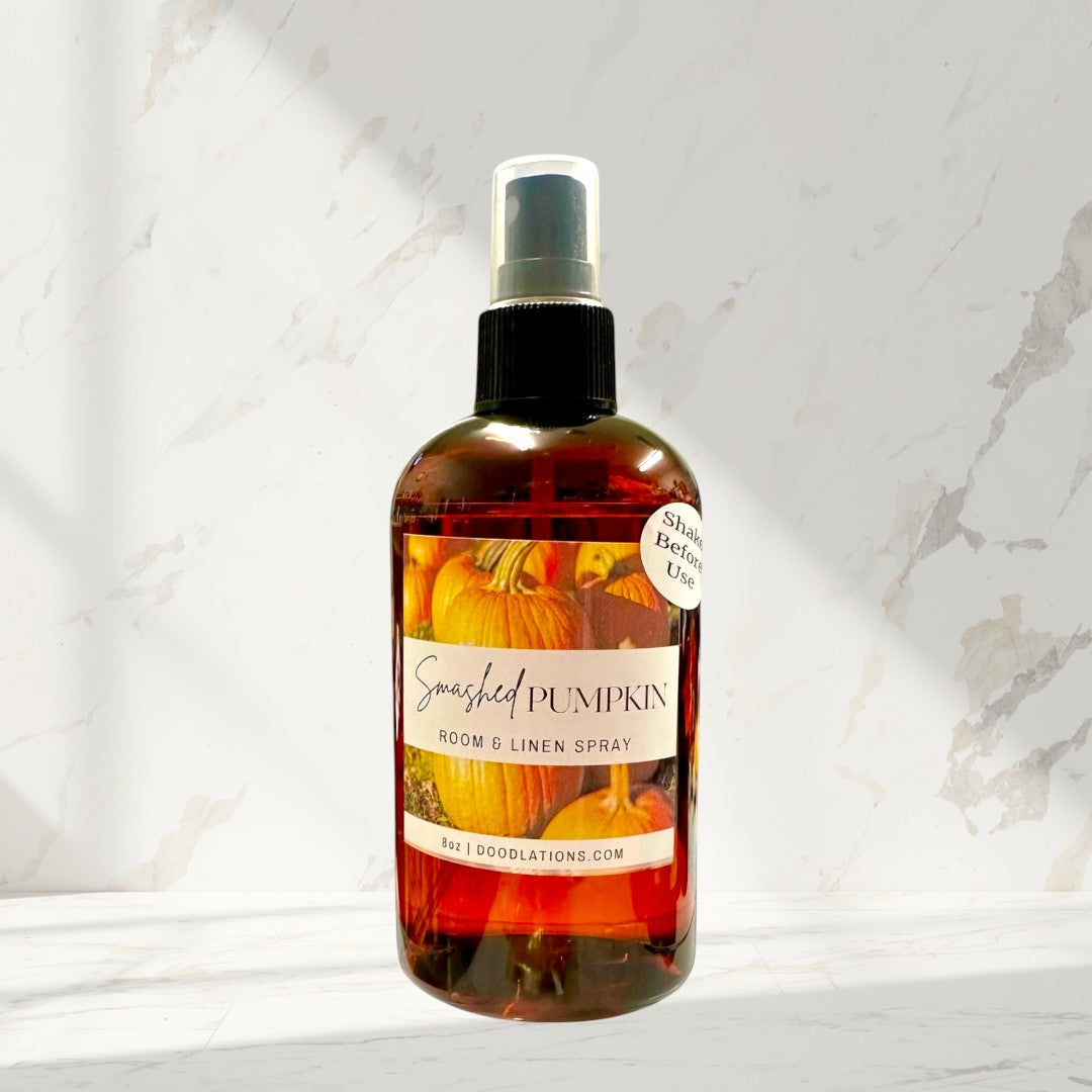 Doodlations Coffee Bar & Boutique Smashed Pumpkin Room & Linen Spray, 8oz bottle with pumpkin imagery. Notes of pumpkin, coconut, cassia, clove, bourbon, maple, and oak.