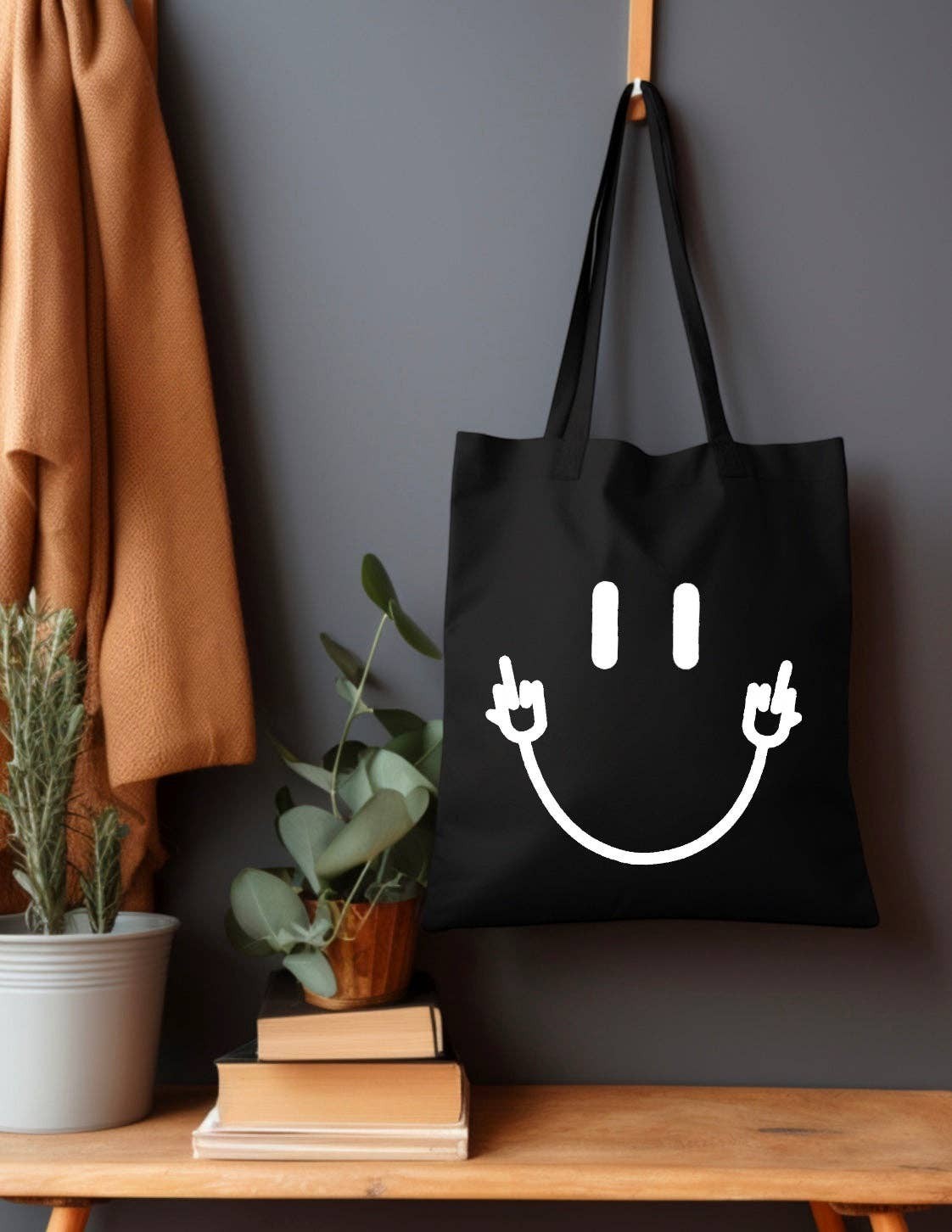 Doodlations black canvas tote bag with white smiley face giving peace and middle finger signs.
