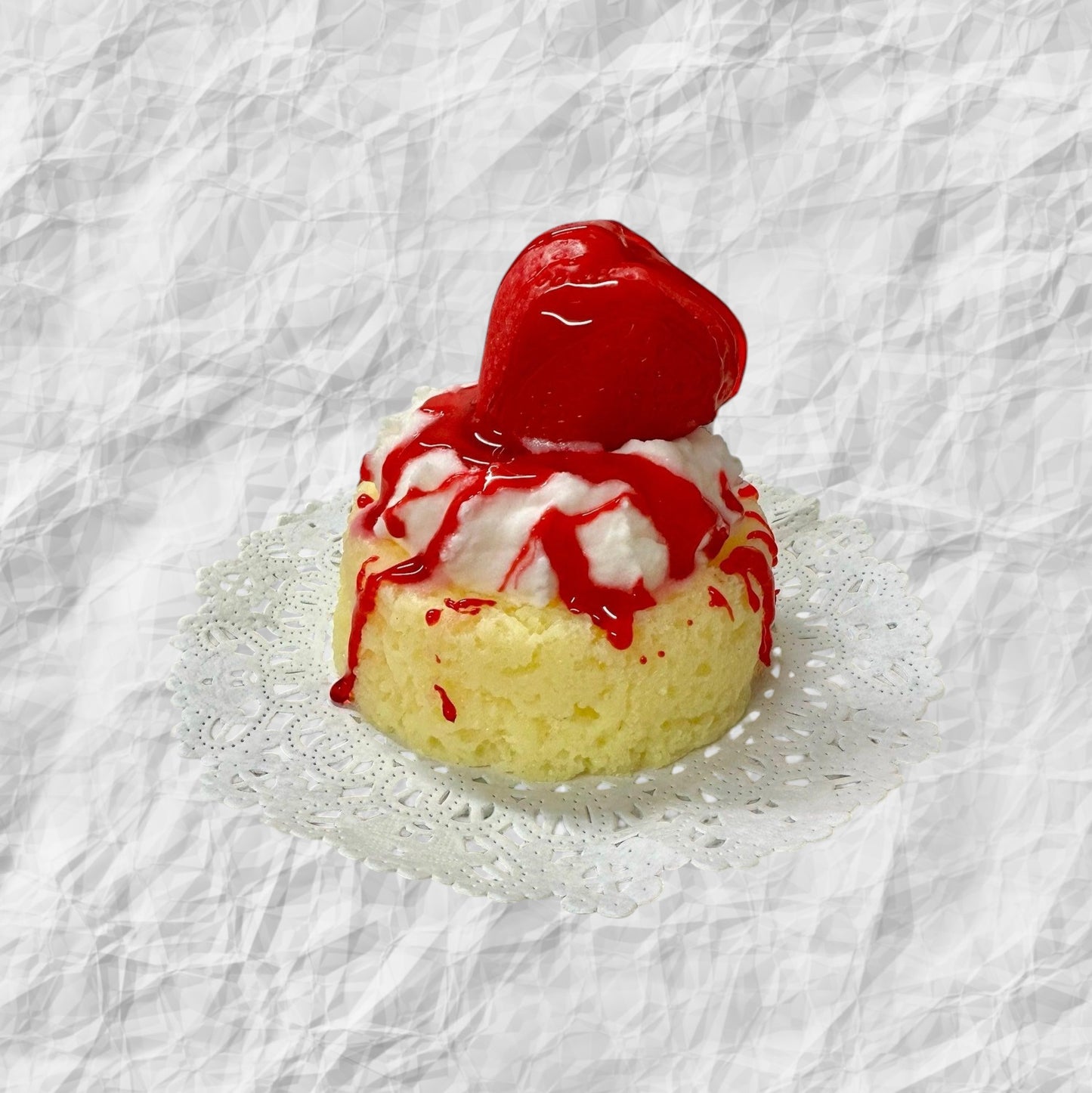Doodlations Strawberry Shortcake luxury wax melt designed to look like a dessert, with yellow cake, white frosting, and red strawberry topping.