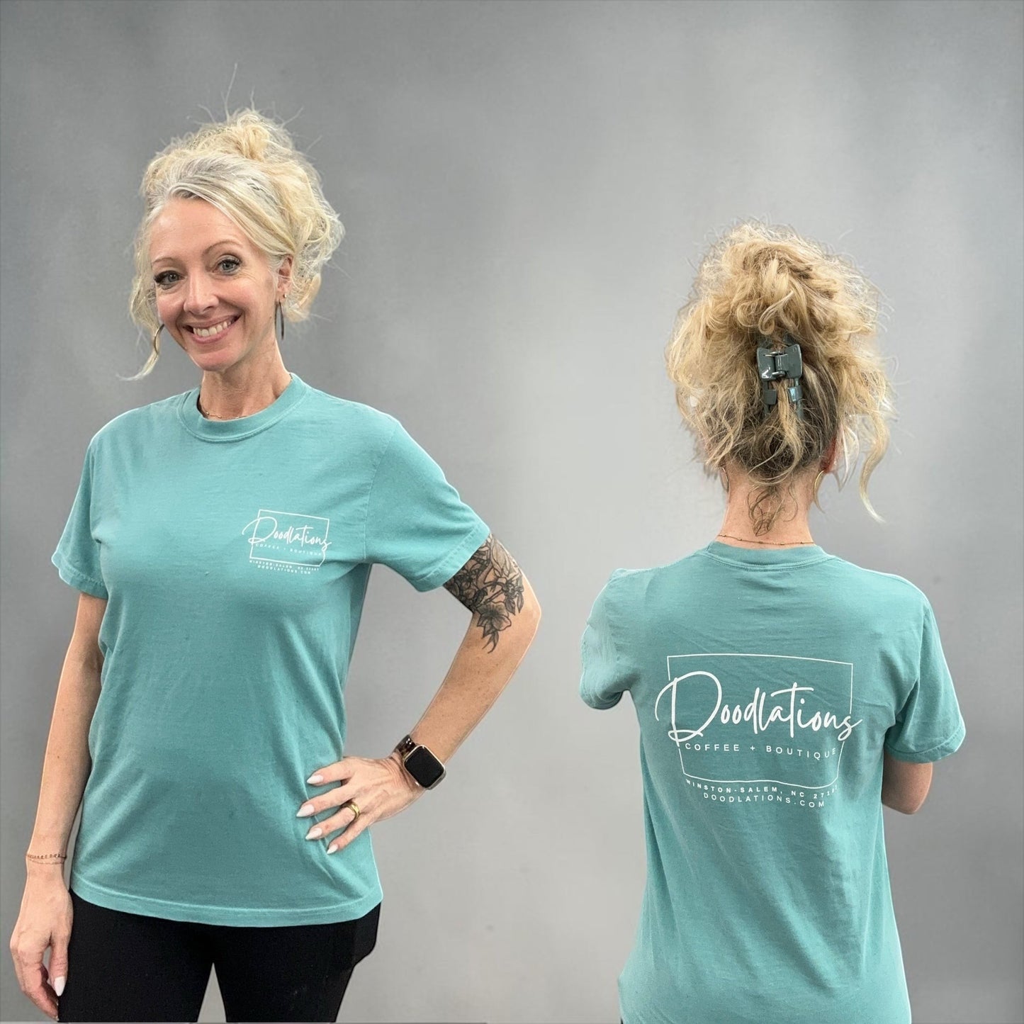 Doodlations Coffee Bar & Boutique teal graphic tee with minimalist logo on front and back. Model wears a relaxed fit t-shirt.