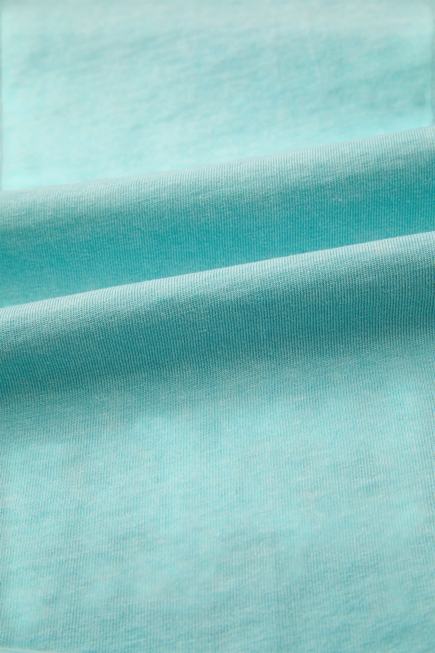 Doodlations Coffee Bar & Boutique teal mineral wash cotton blend relaxed fit tee with raw edge hem and sleeves.