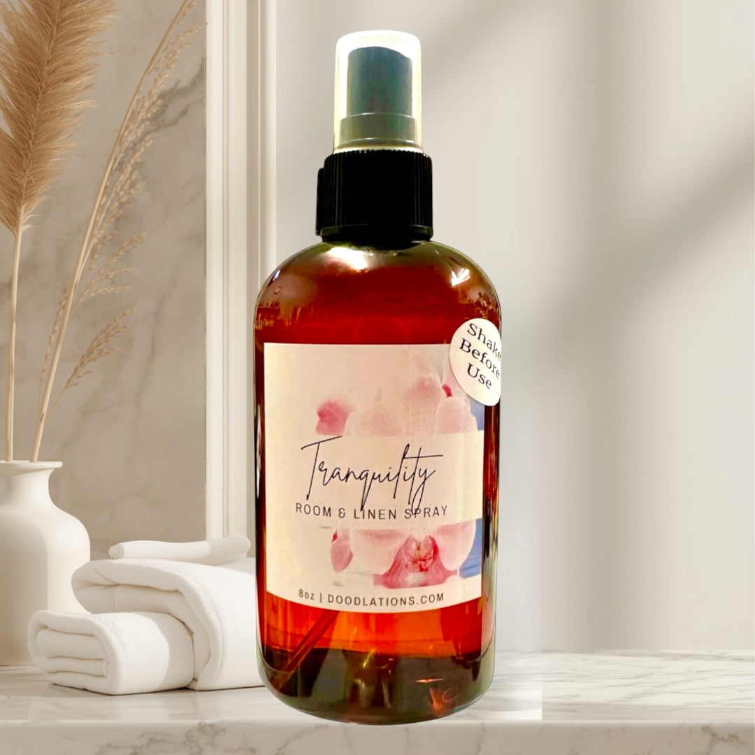Doodlations Tranquility Room & Linen Spray with lemongrass, clove, lavender, and musk scents. 8oz amber bottle.
