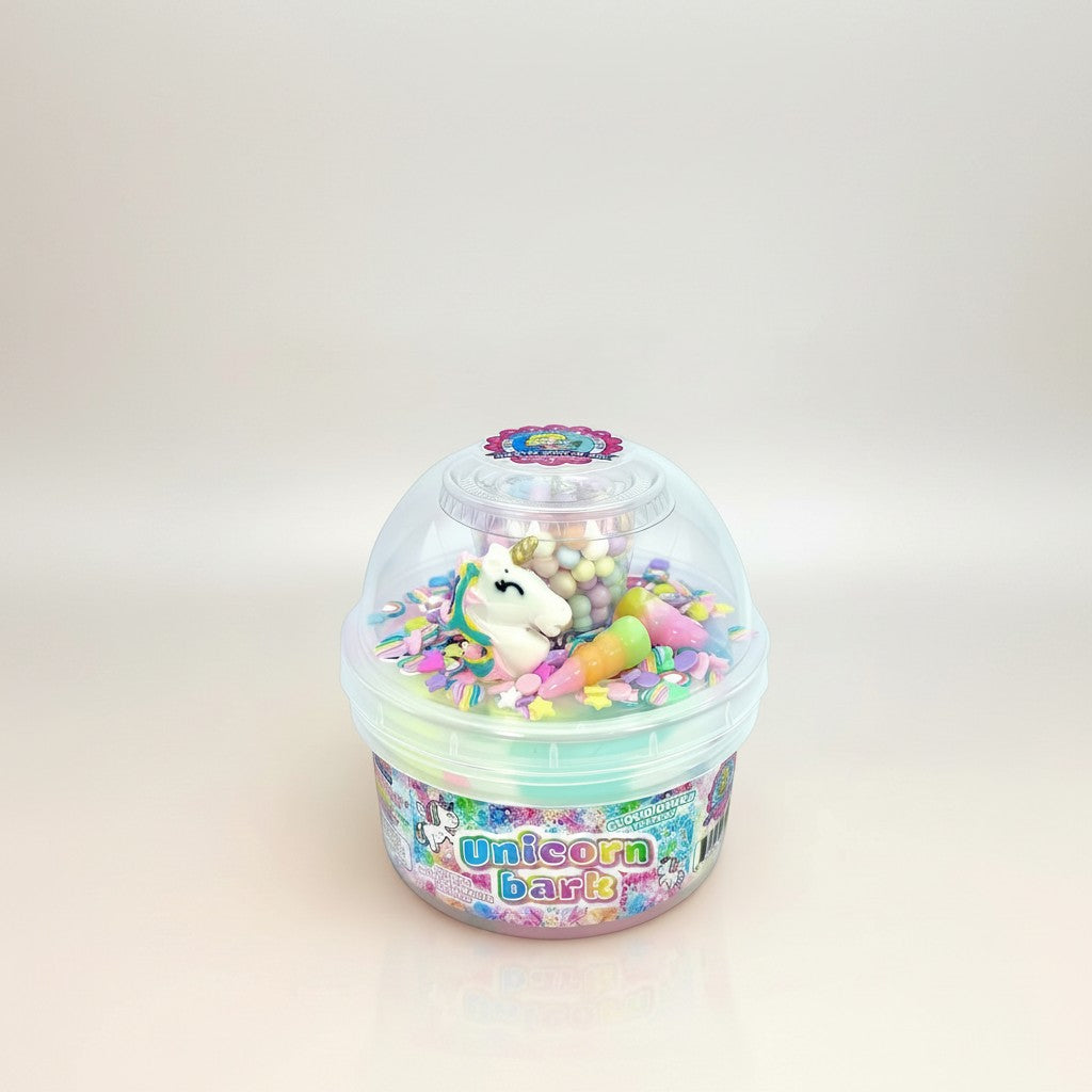 Doodlations Unicorn Bark cloud dough slime with pink, blue, and lavender swirls, topped with unicorn charm, pastel beads, sprinkles, and ice cream cone charms.