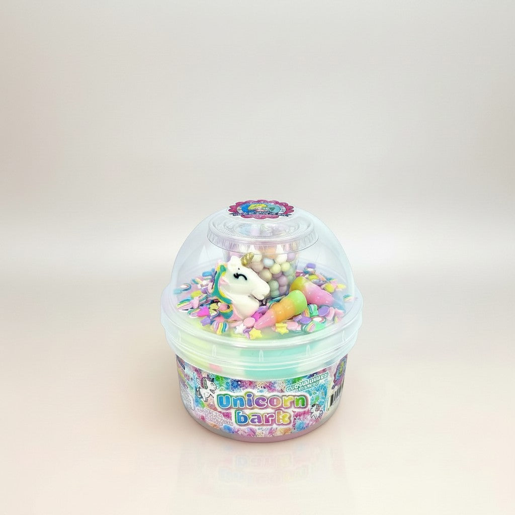 Doodlations Unicorn Bark slime in a clear container with pastel pink, blue, and lavender swirls, topped with unicorn charm, sprinkles, and floam beads.
