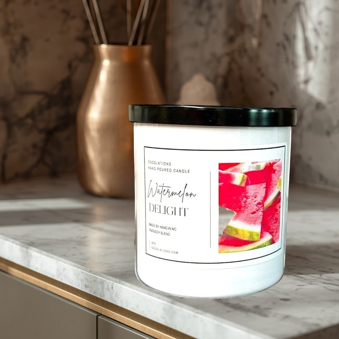 Doodlations Watermelon Delight hand-poured soy blend candle with a black lid, featuring a label with sliced watermelon.
