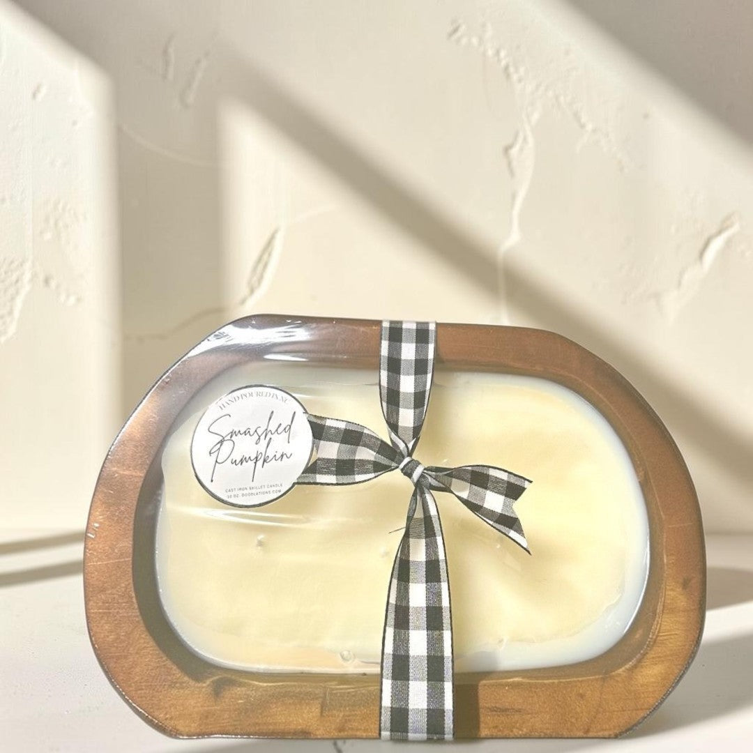 Doodlations Smashed Pumpkin wooden dough bowl candle with black and white buffalo check ribbon.