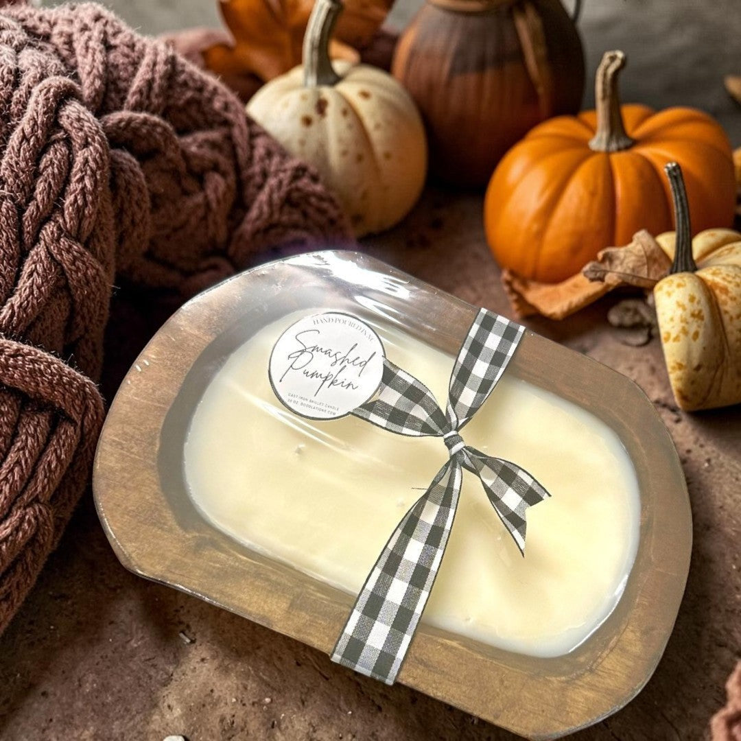 Doodlations Smashed Pumpkin wooden dough bowl candle with a black and white gingham ribbon.