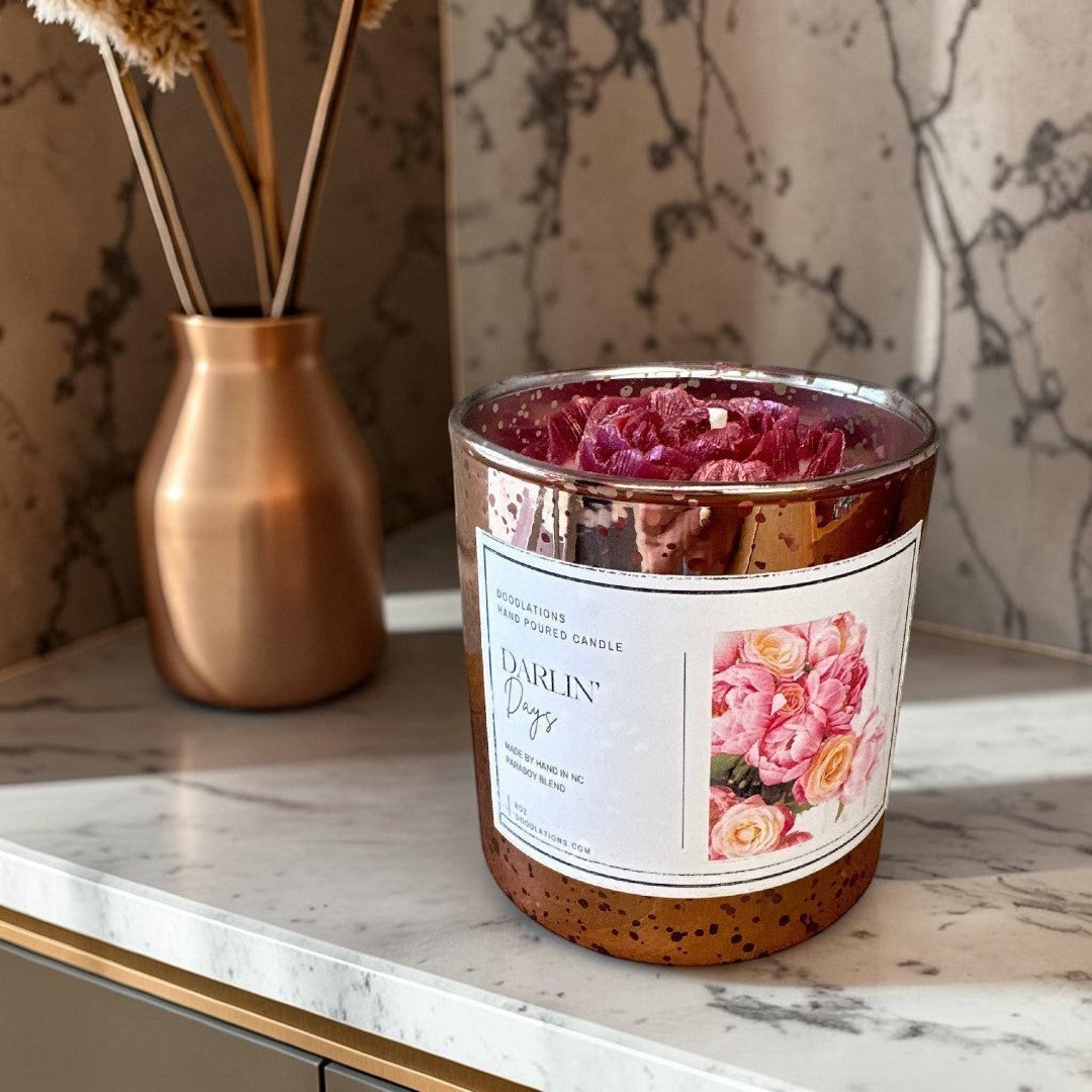 Doodlations Darlin' Days Floral hand-poured candle in a rose gold mercury glass jar with pink and cream rose decorations.